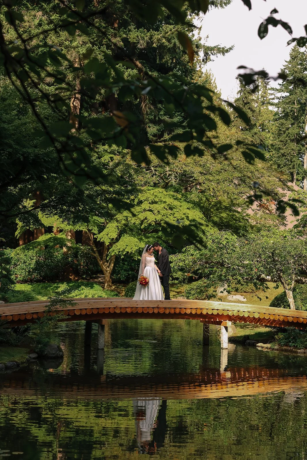 A bride and groom standing on a bridge in Nitobe Garden in Vancouver