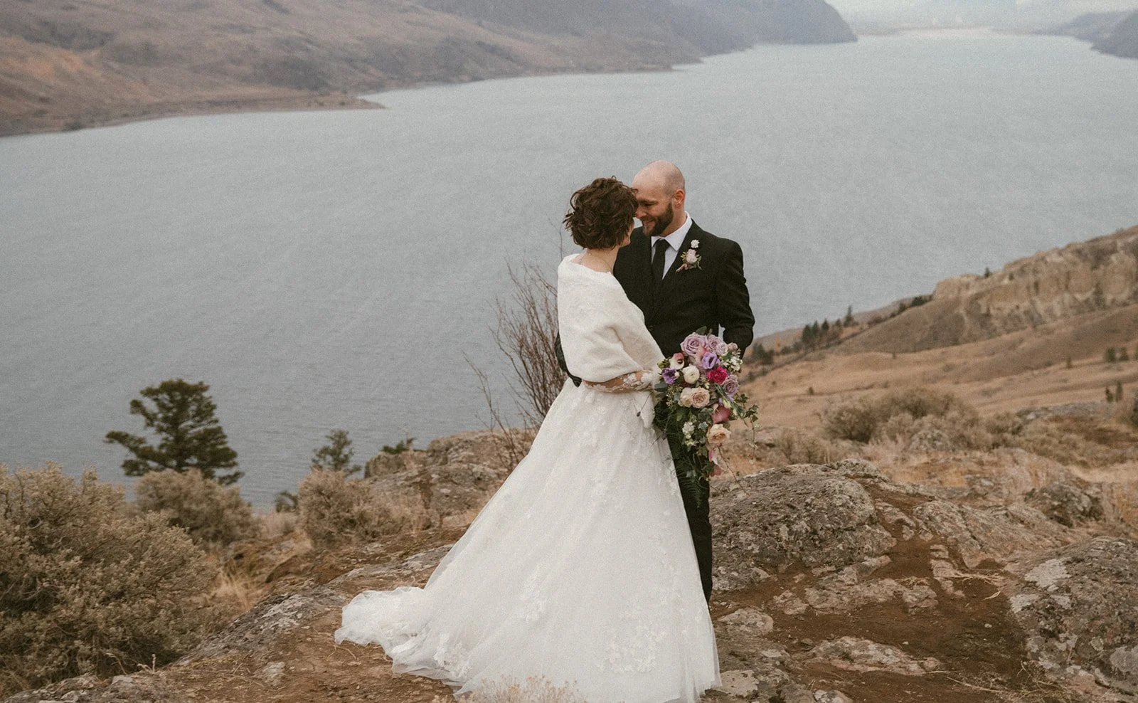 A happy bride and groom eloping, lake in the background
