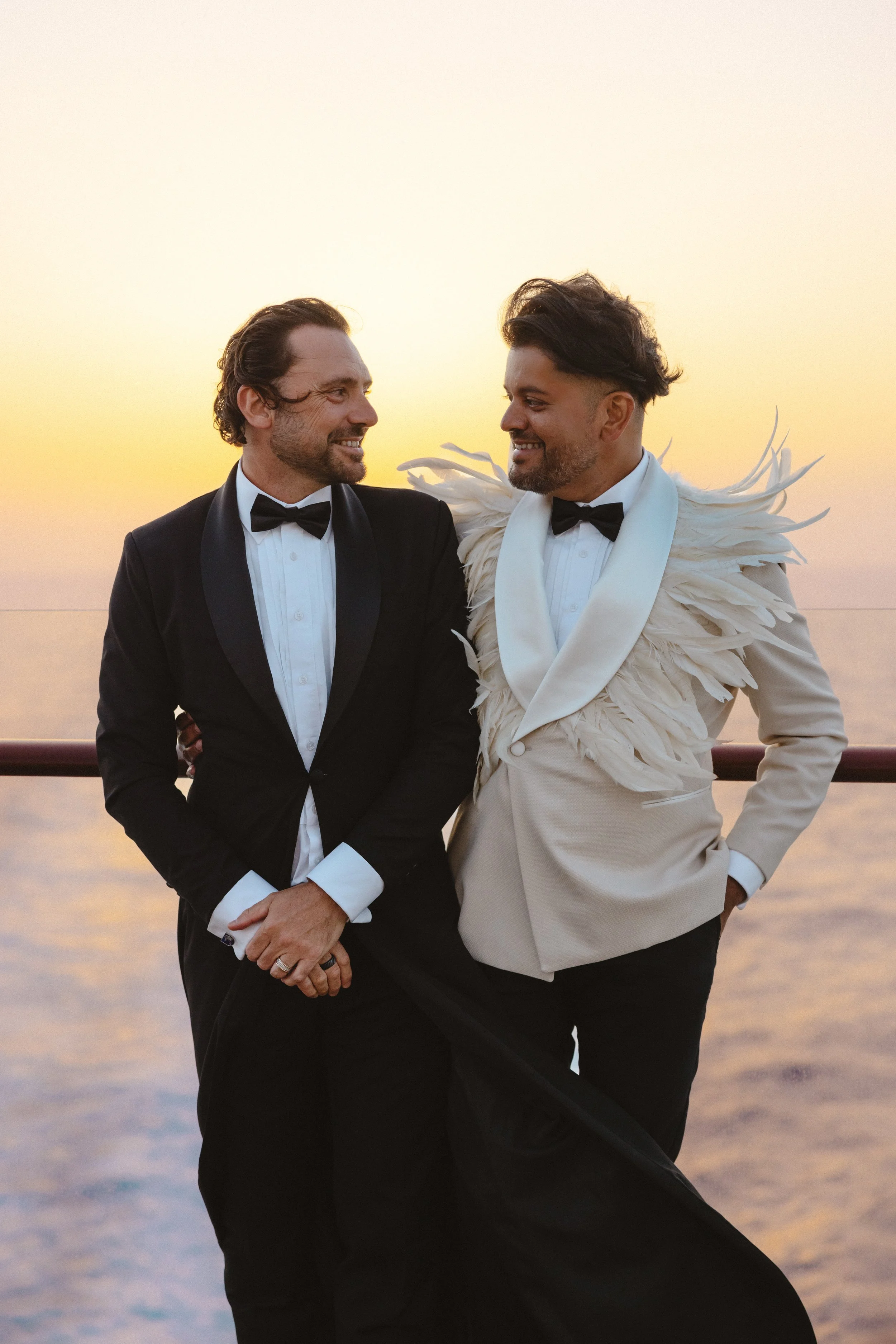 Newlyweds standing with clear water in the background