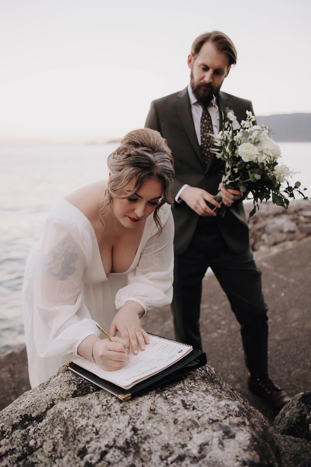 A bride and groom signing their marriage documents
