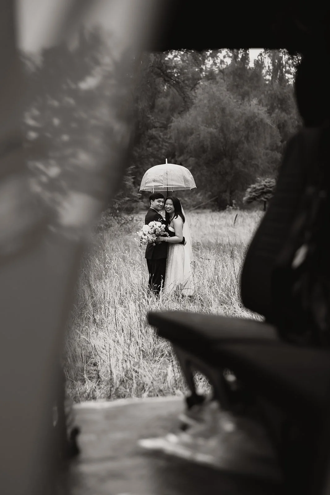 Bride and groom under umbrella at Douglas Island helicopter elopement in BC.