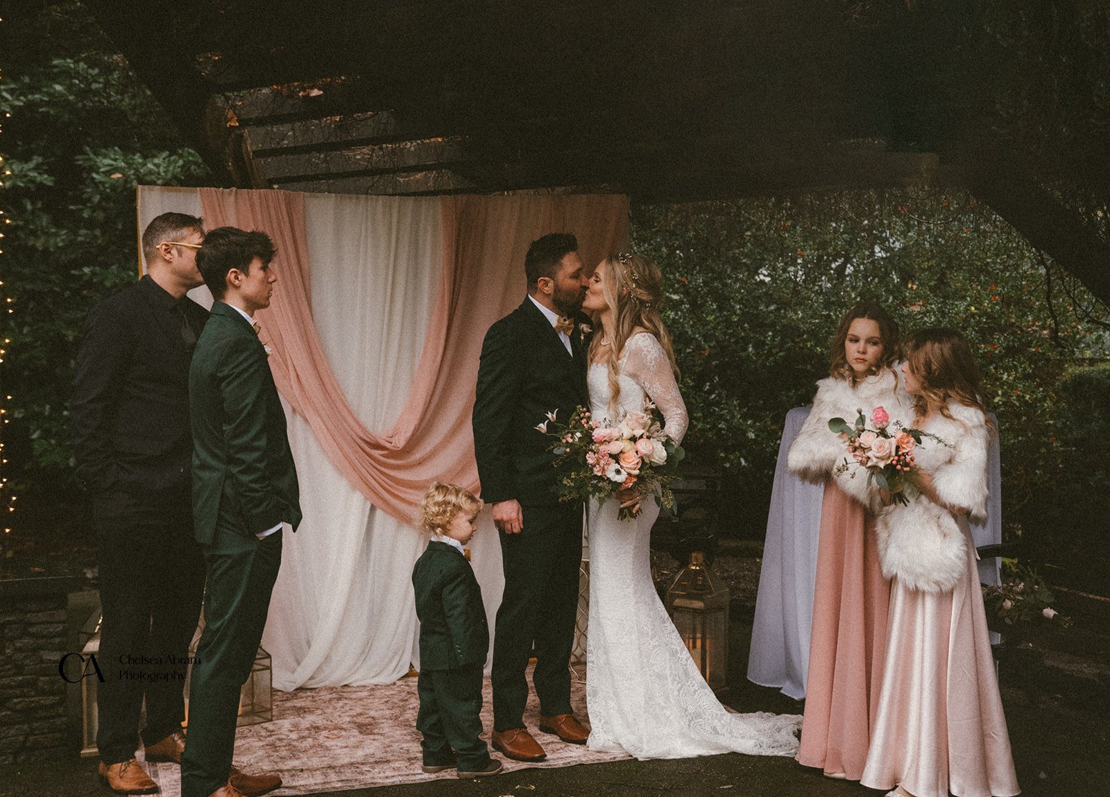 A bride and groom kissing at the altar