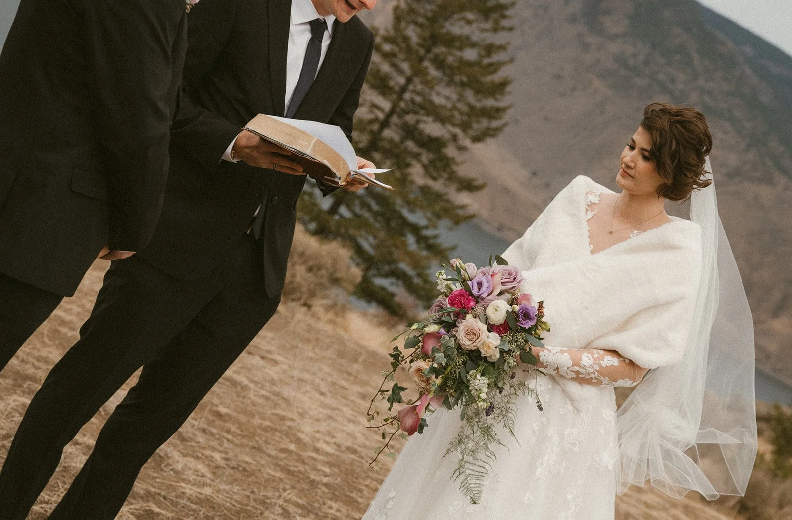 A bride listening to their officiant read a passage