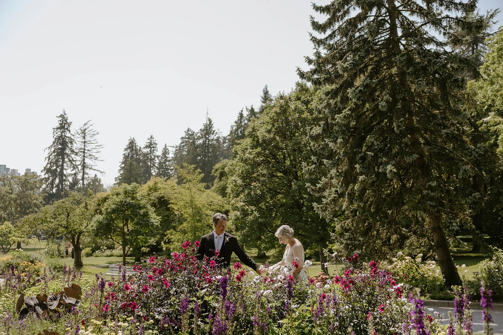 Newlyweds walking through the flowers of Stanley Park Rose Garden