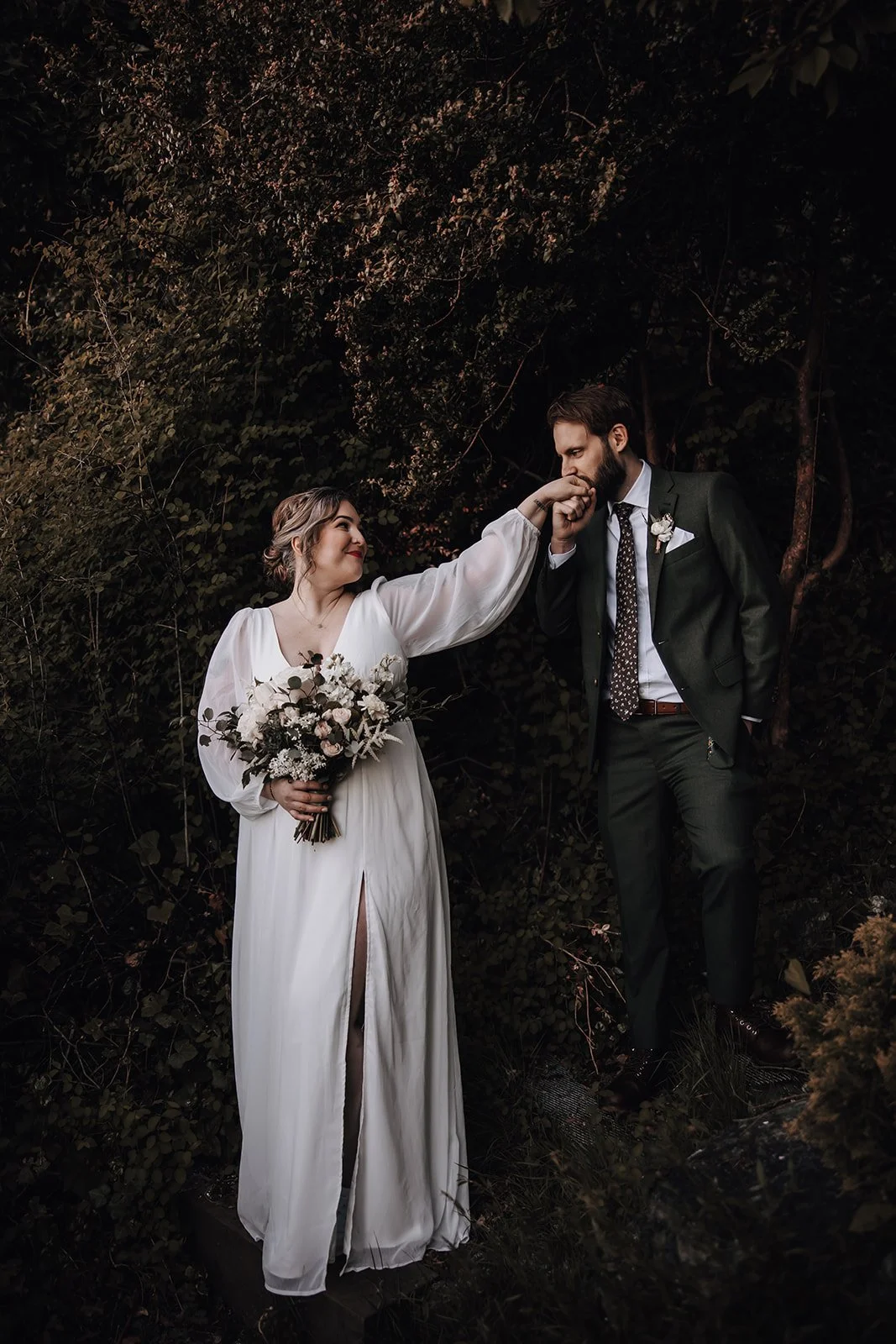A groom kissing his bride's hand during their elopement
