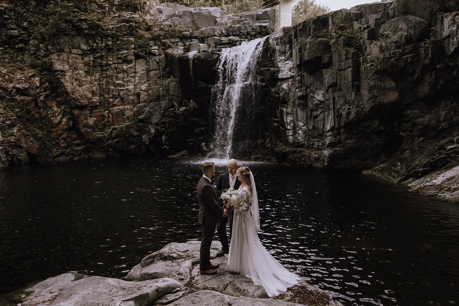 A couple eloping under a waterfall in Powell River BC