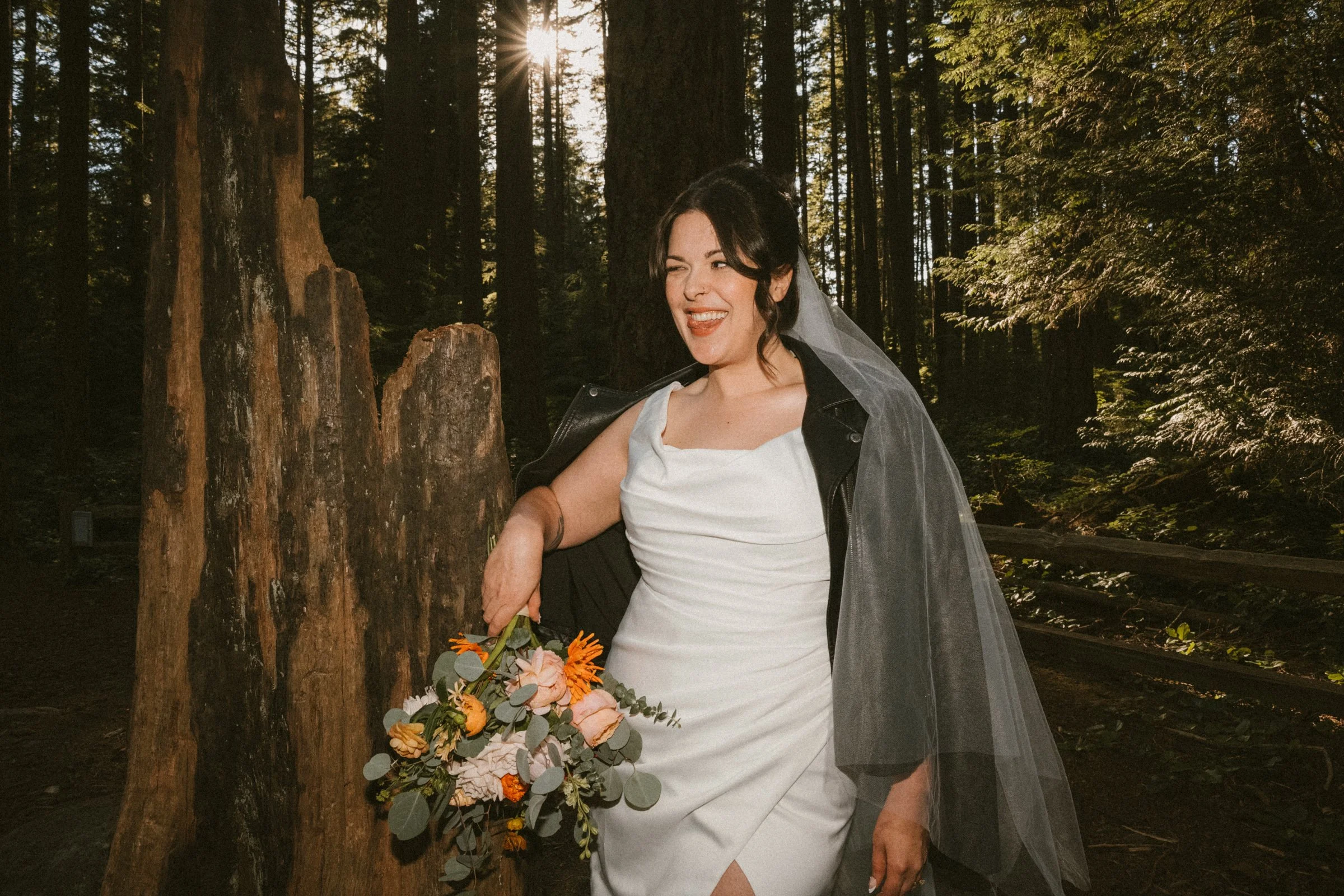 A sassy bride with a leather jacket after her elopement in Pacific Spirit Park