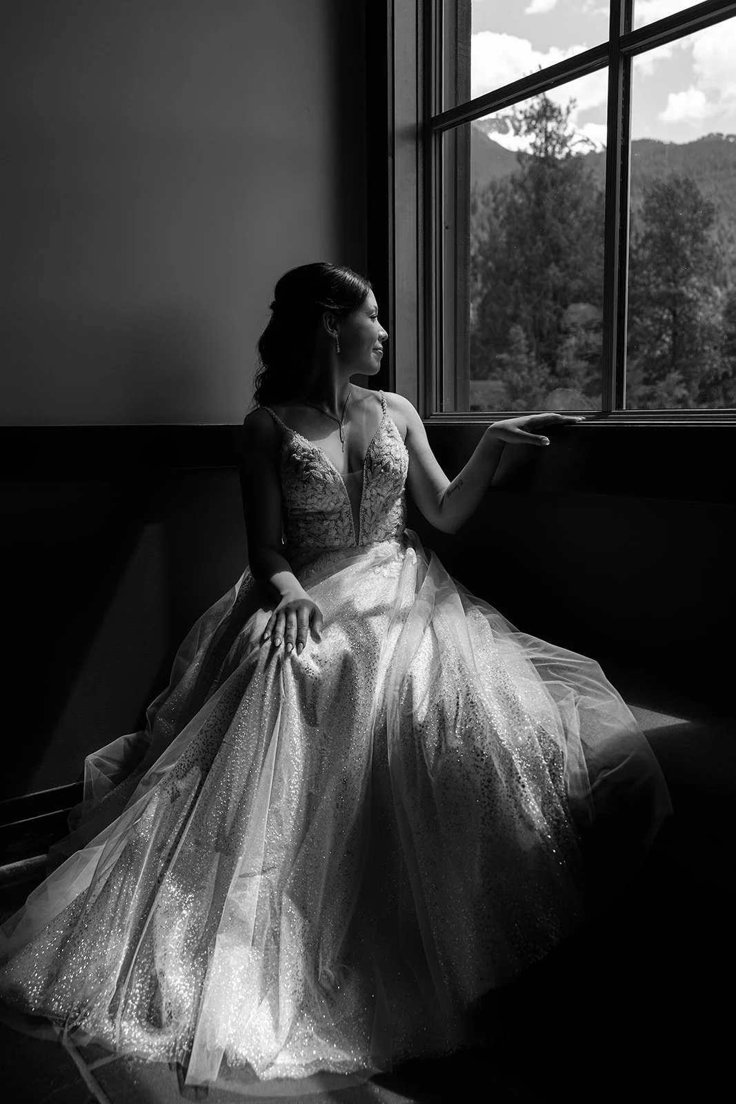 A black and white photo of a bride during her elopement, looking out at Whistler, BC