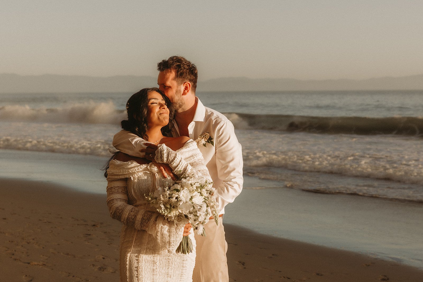 A couple embracing on one of BC's many beautiful beaches.