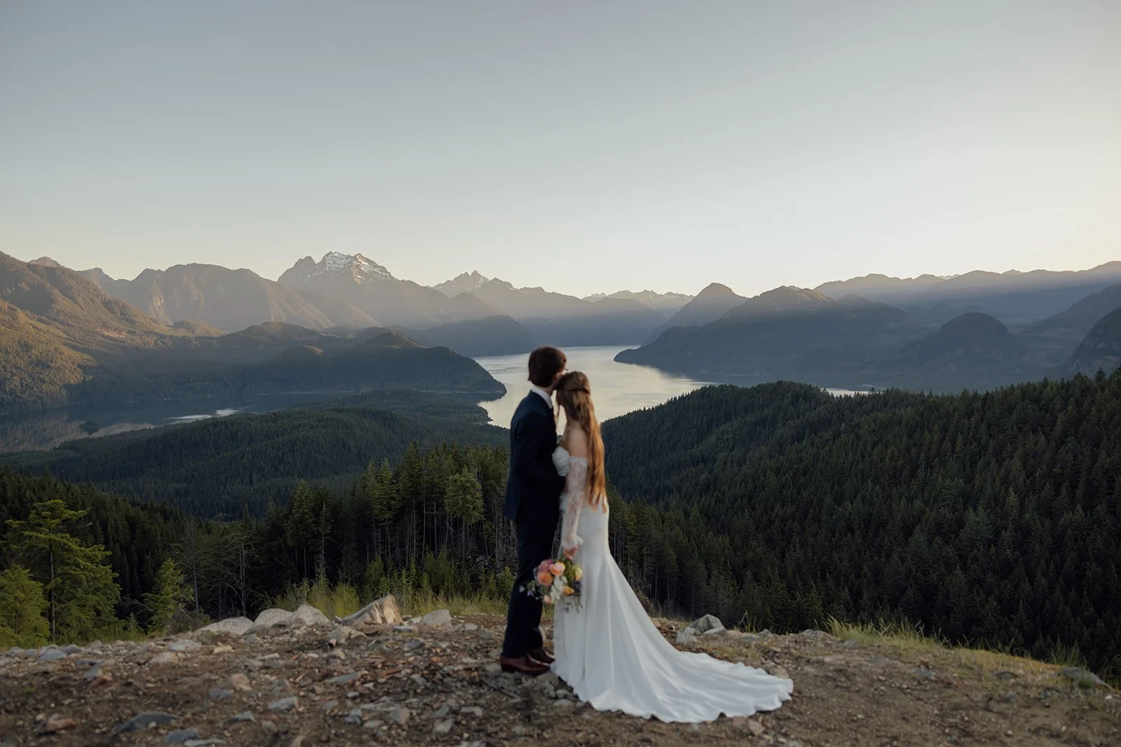A bride and groom, eloping while looking over Pitt Lake