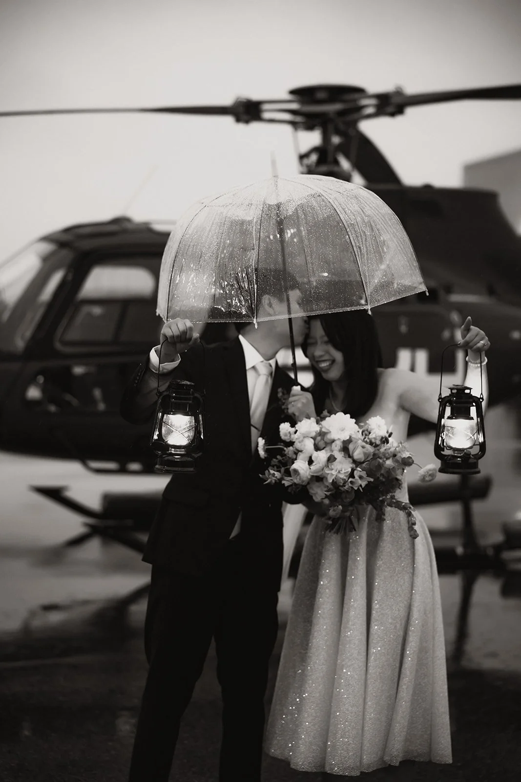 A groom kissing his bride as they prepare for their helicopter elopement
