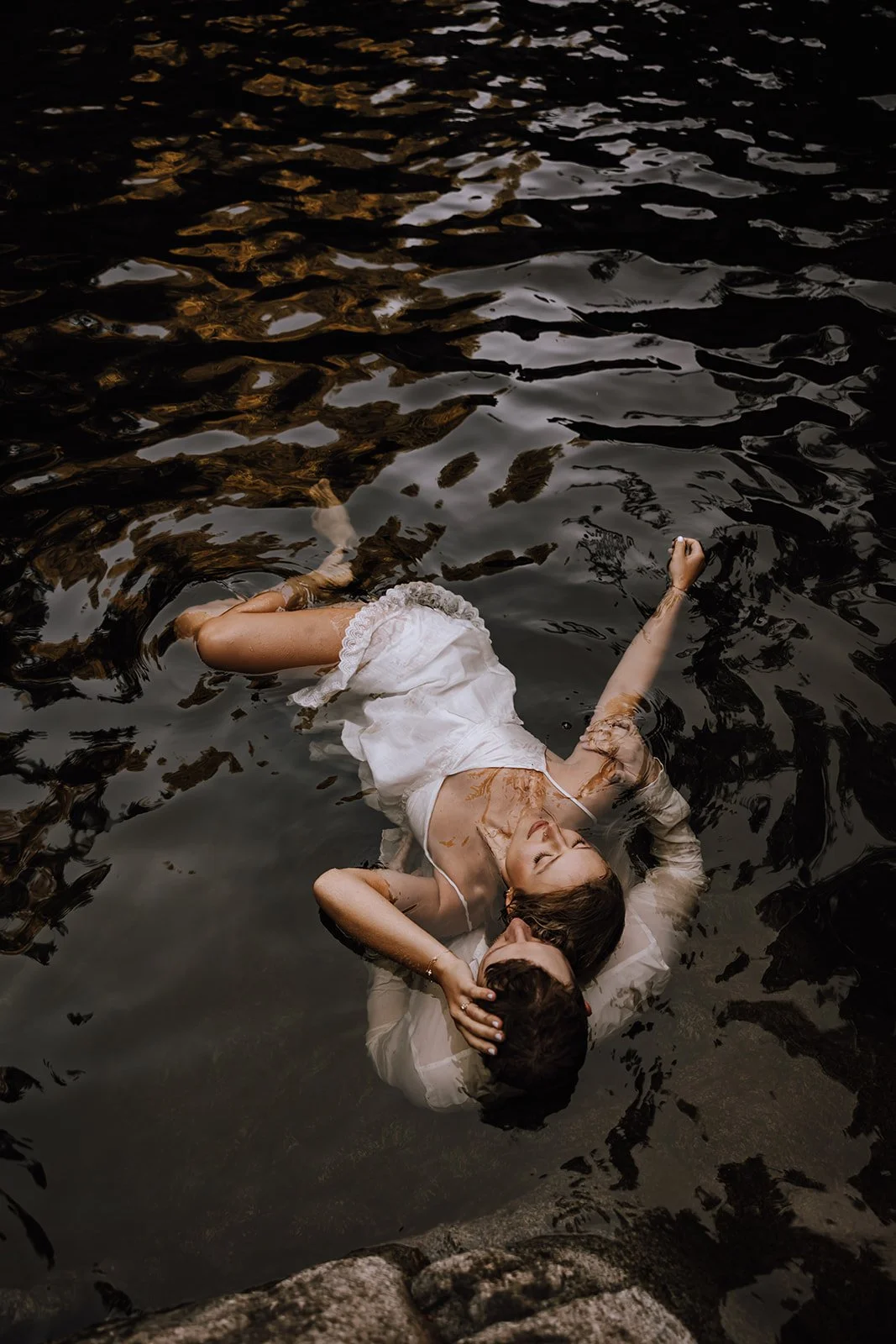 Couple floating in a secluded BC lake, sharing a tender kiss as they elope