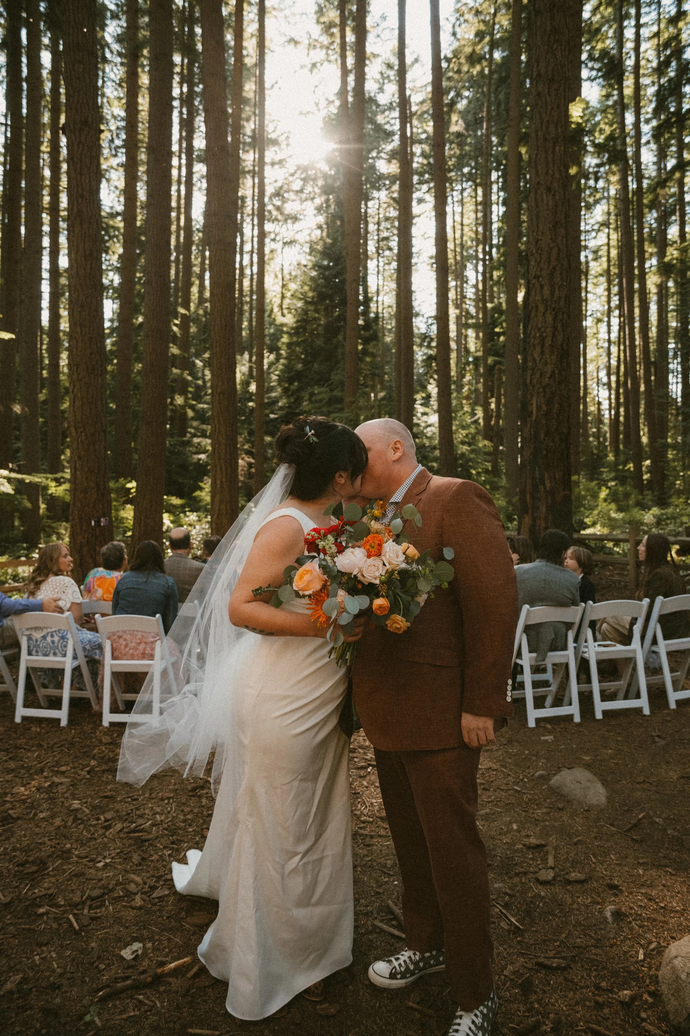 Bride and groom eloping in Pacific Spirit Park, their guests in the background