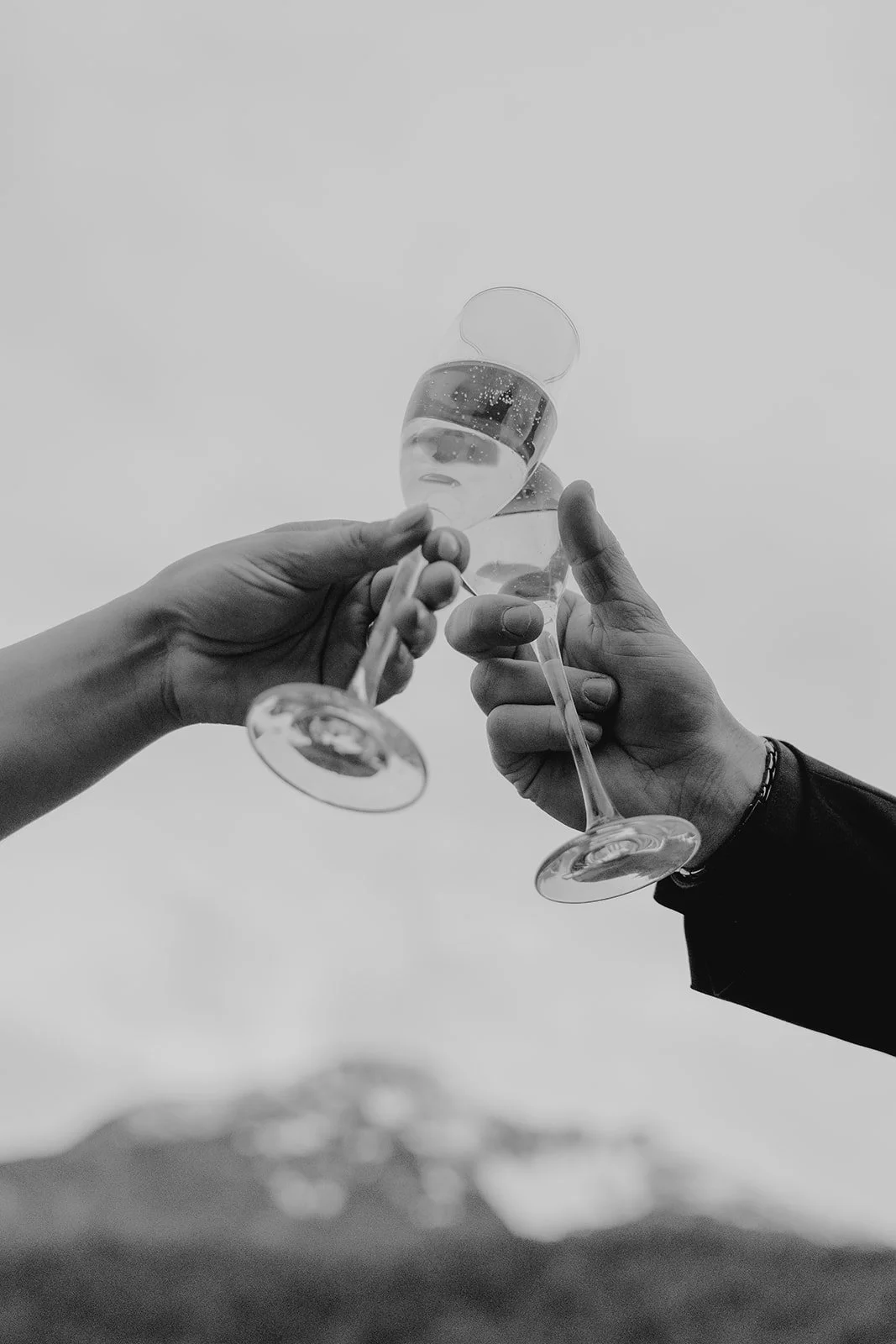 Newlyweds sharing a champagne toast in a classic black and white wedding portrait