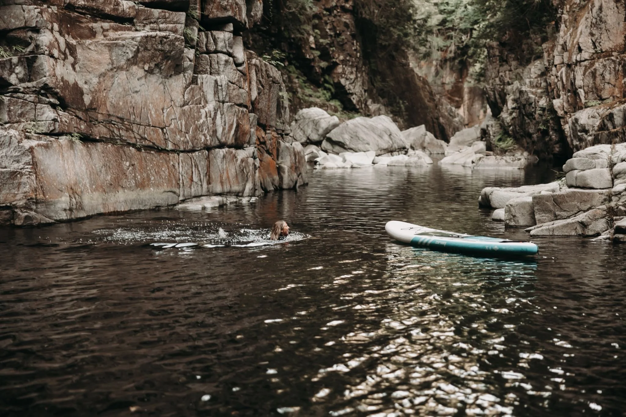 Adventure elopement moment with Jocelyn Bacon swimming in a lake