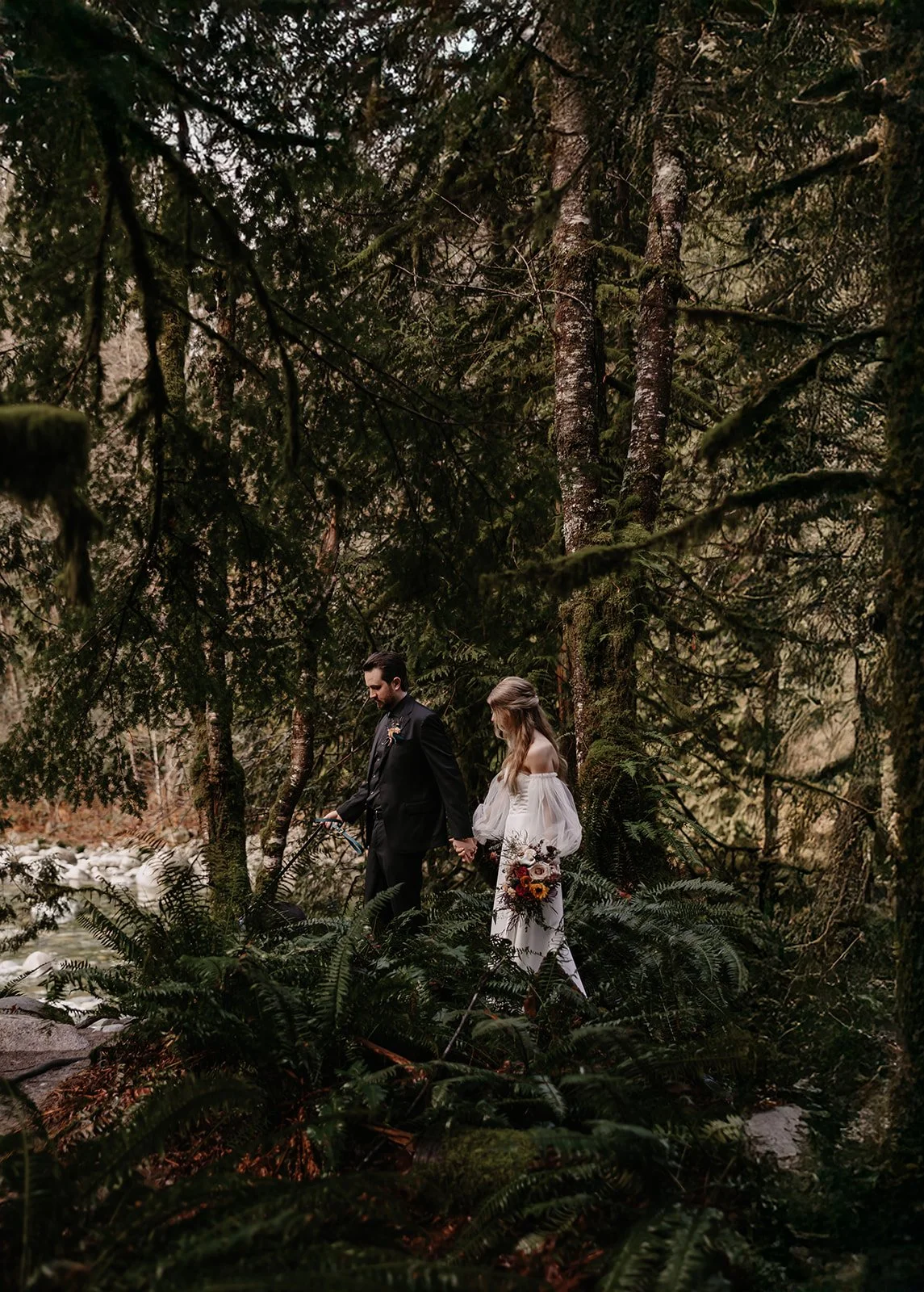 A newly eloped couple walking through the forest in Lynn Valley, North Vancouver