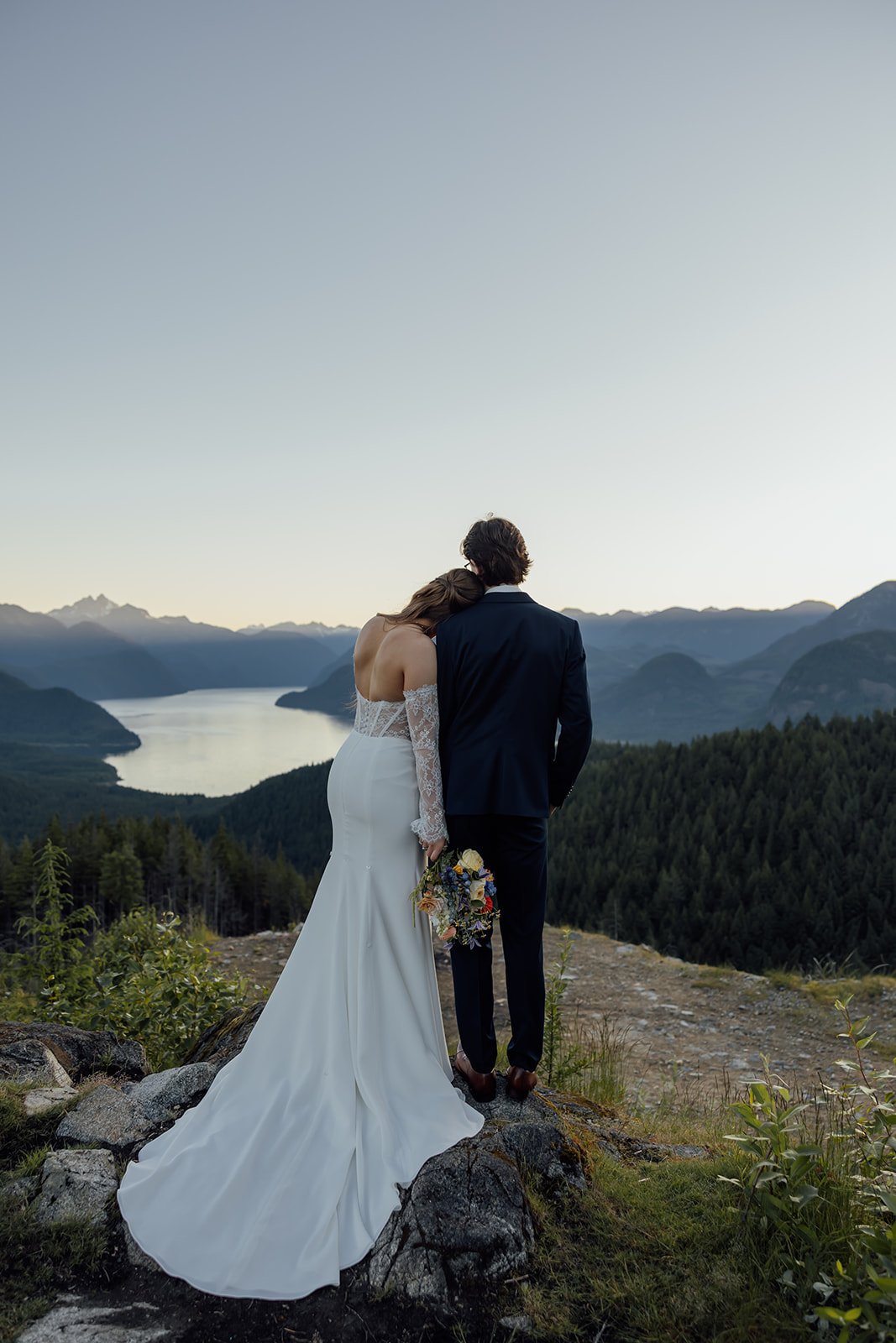 A bride and groom looking out over Pitt Lake during their elopement