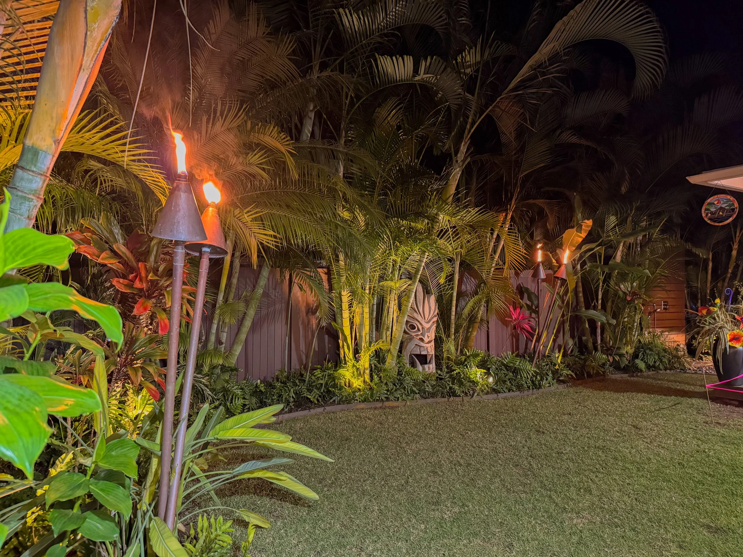 Copper tiki torches in a professionally landscaped back yard 