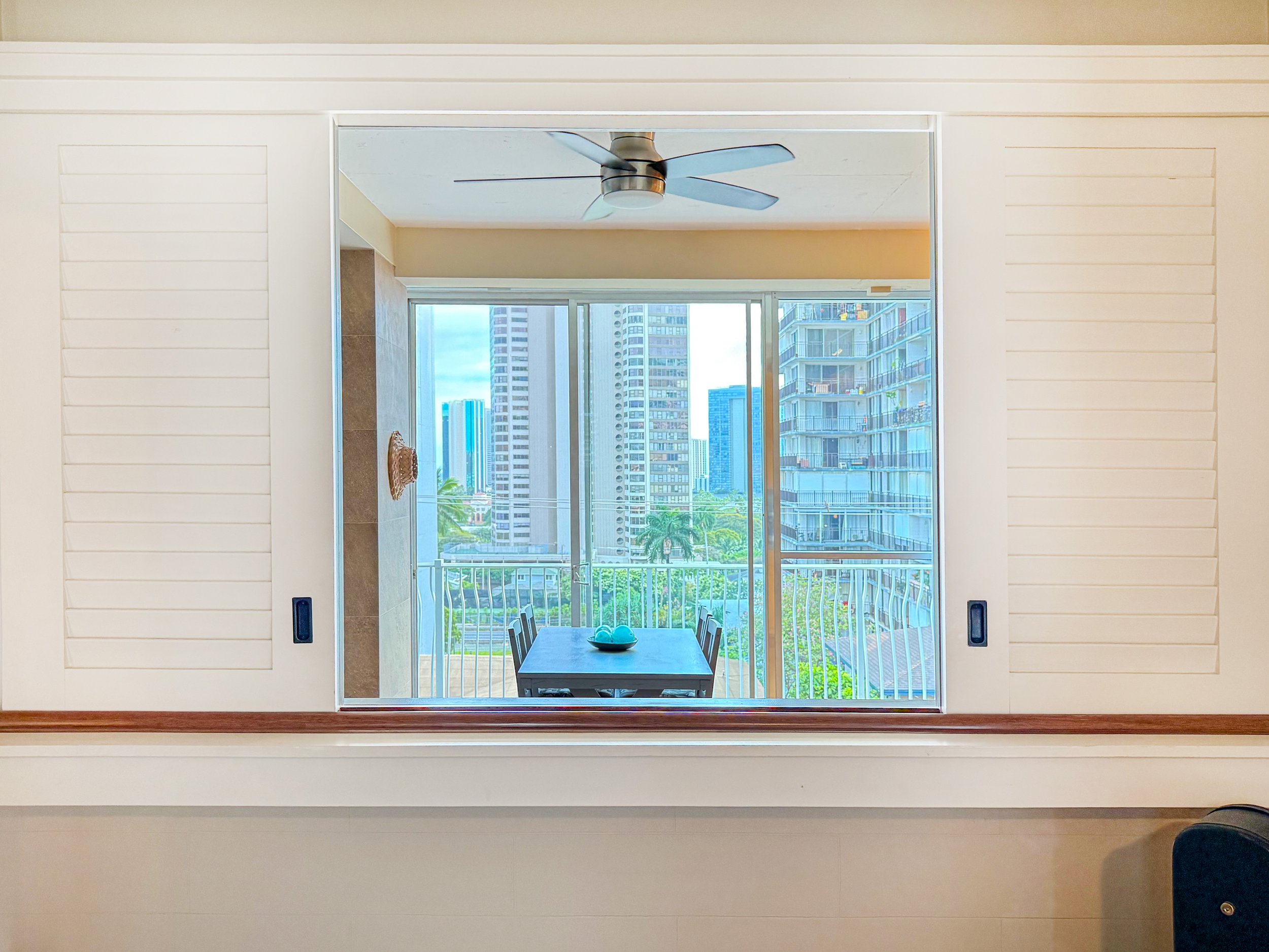 Bedroom window opening to the living area and Honolulu skyline views
