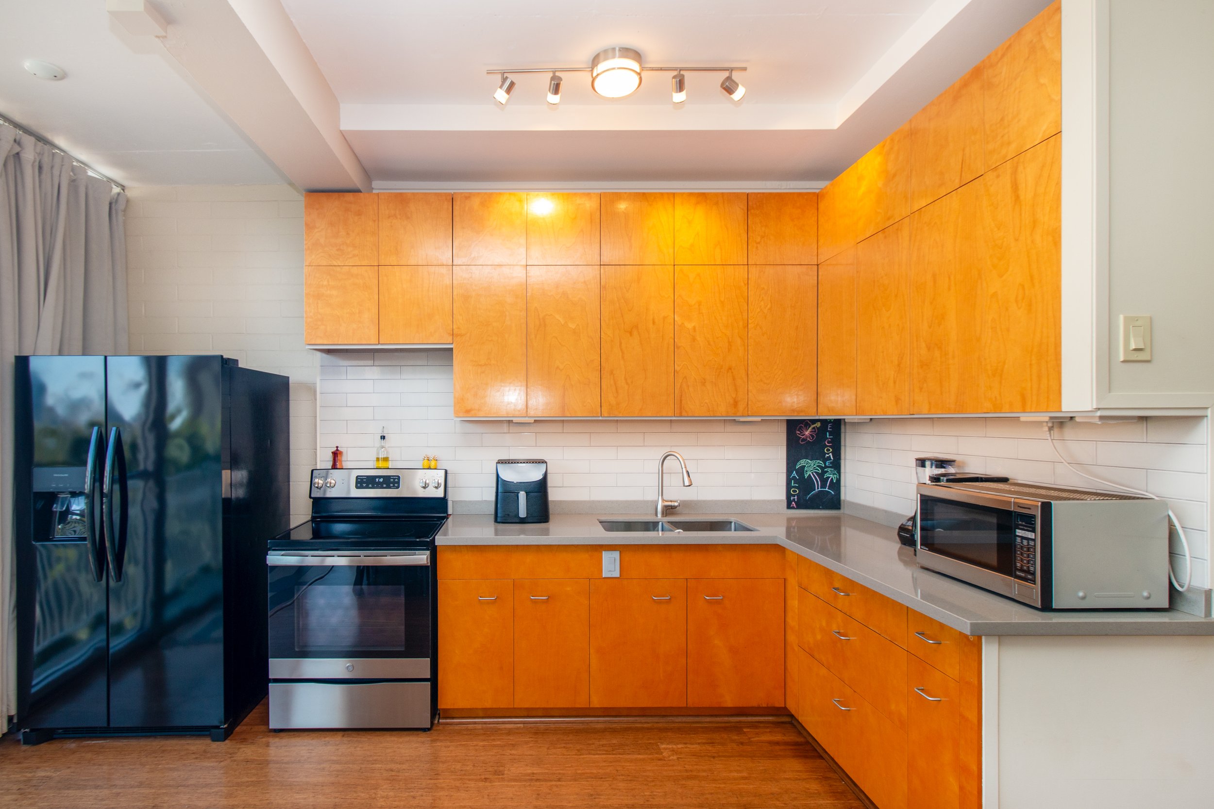 Open kitchen was partially remodeled in spring 2022, upgrades included new engineered quartz countertops, a kitchen backsplash, removal of the boxed ceiling for a more open feel and electrical improvements.