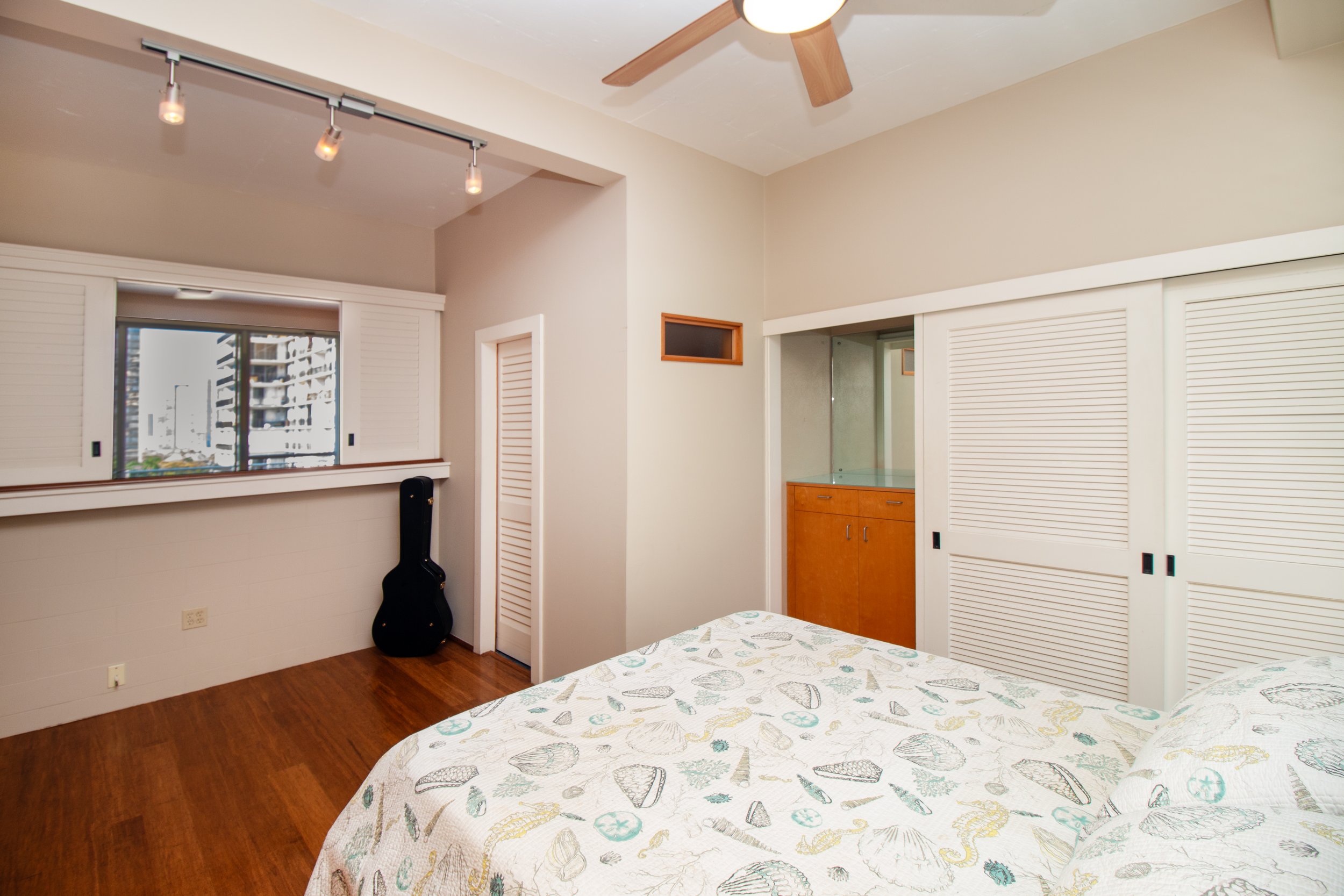 Bedroom with a window opening to the living area and city views.