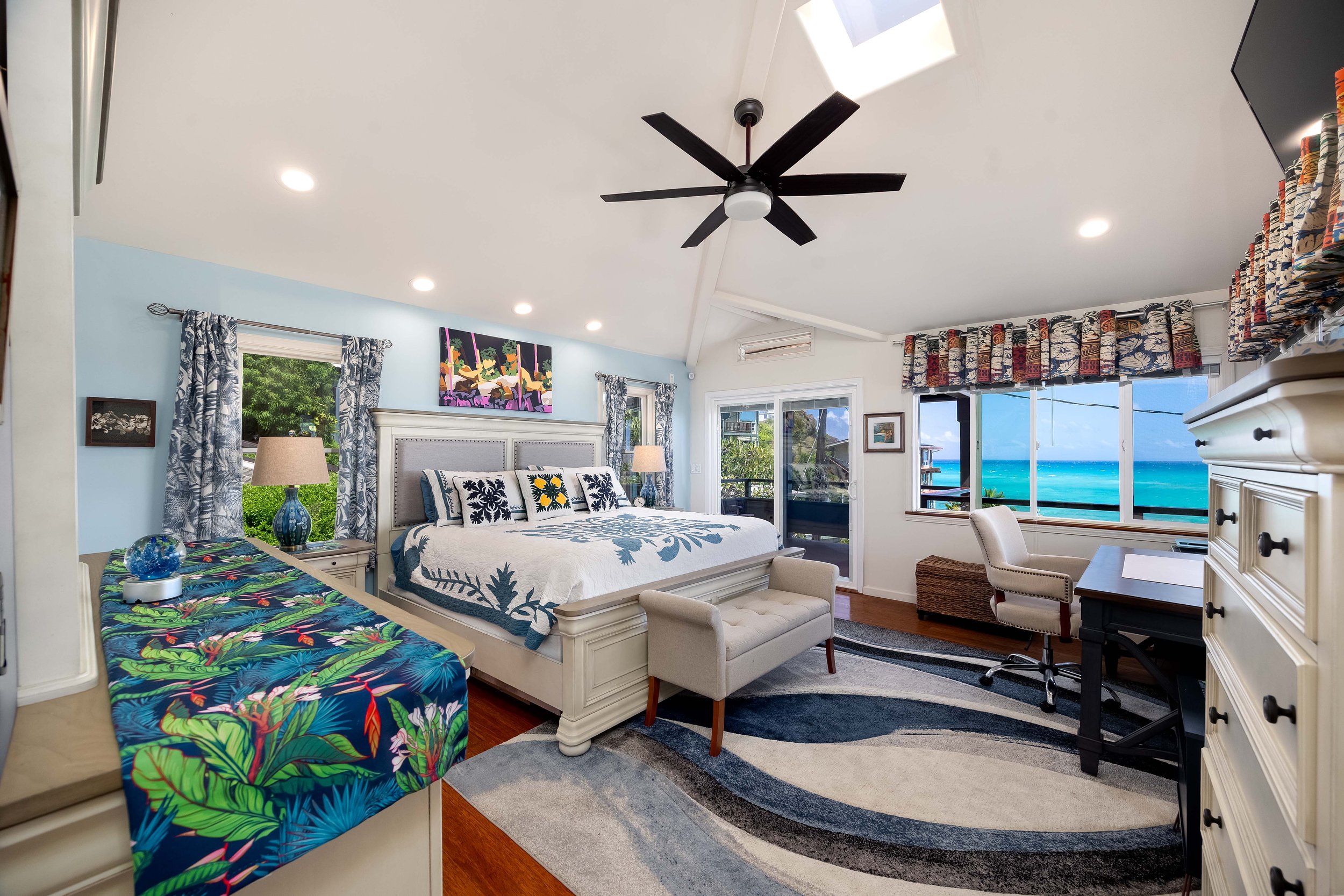 Primary suite on the 2nd floor with hardwood flooring, split ACs, skylight, walk-in closet, spacious bathroom and access to a covered lanai access.