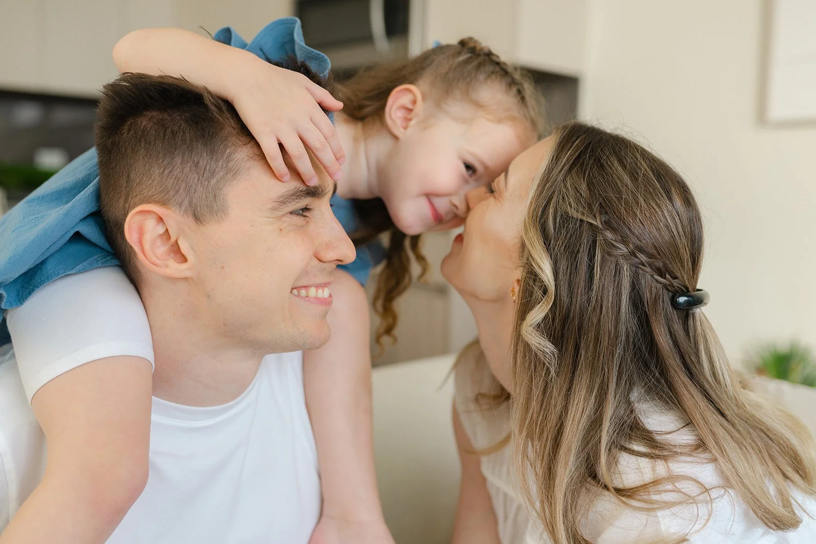 Family sharing a sweet candid cuddle at home during a natural family photos session.
