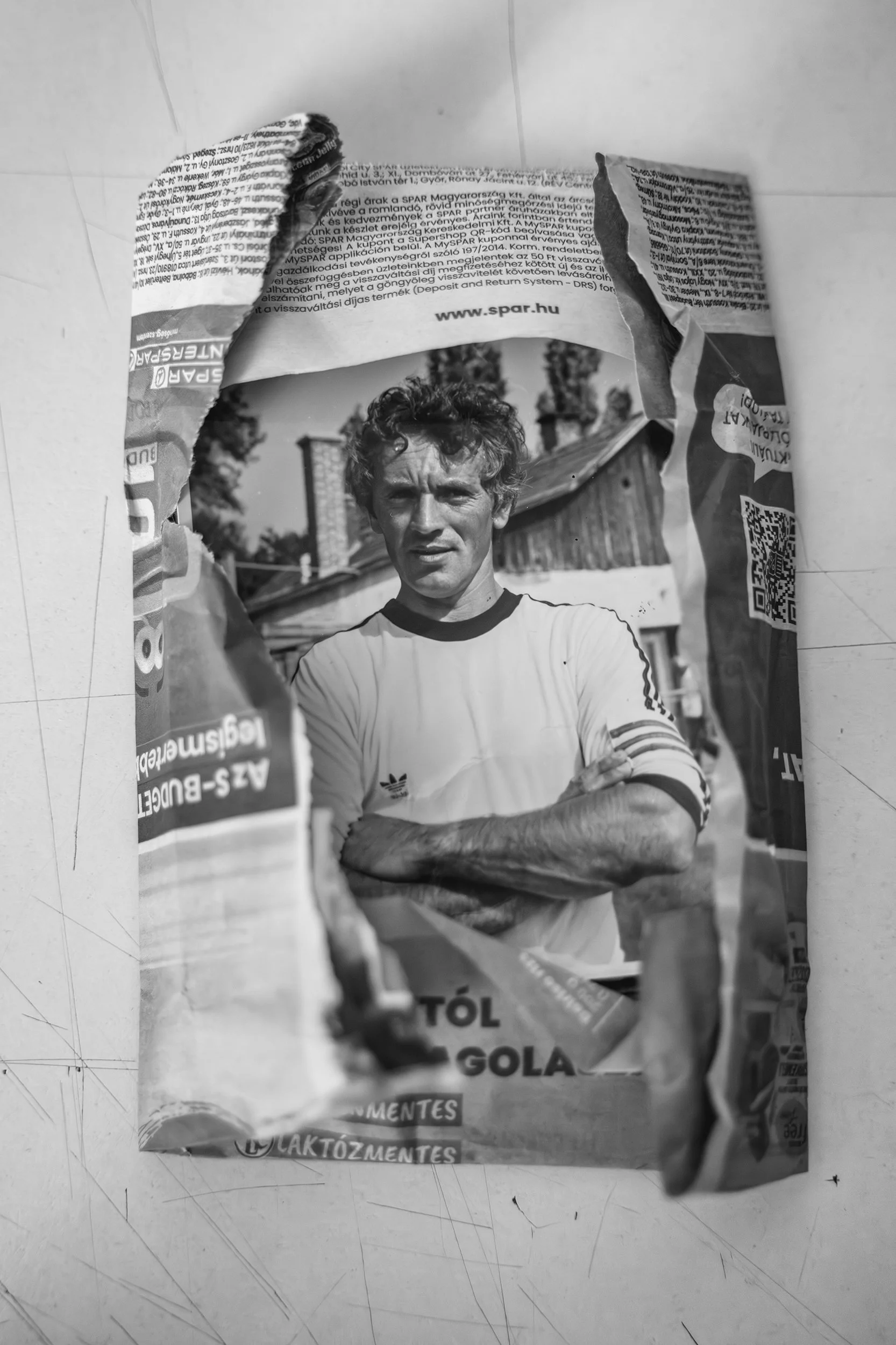 A student's old family photos wrapped in a newspaper advertisement. His grandfather was the captain of their football team. 2026.