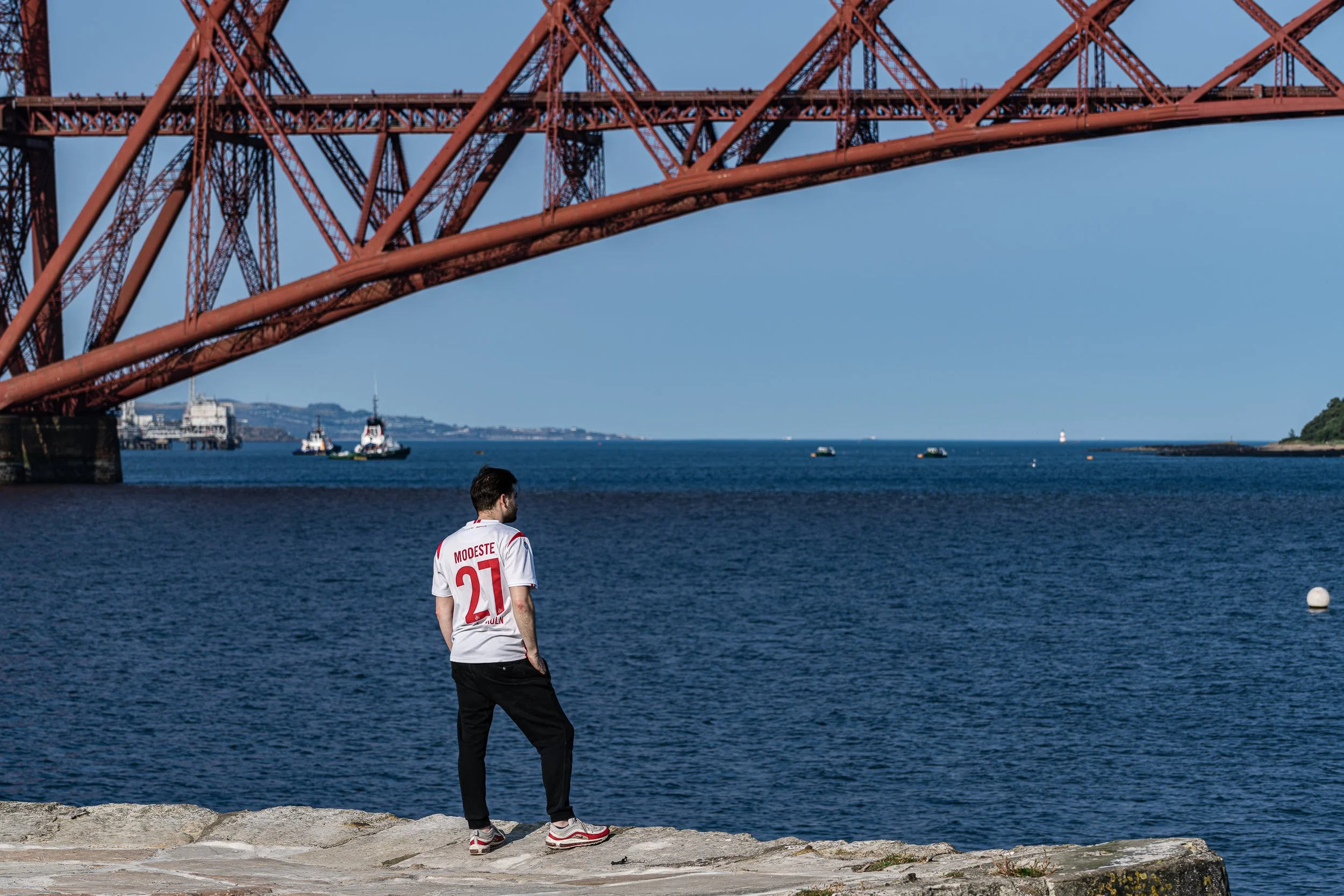 A man came to the harbor to relax, to clear his head after a day at work. South Queensferry. 2024.