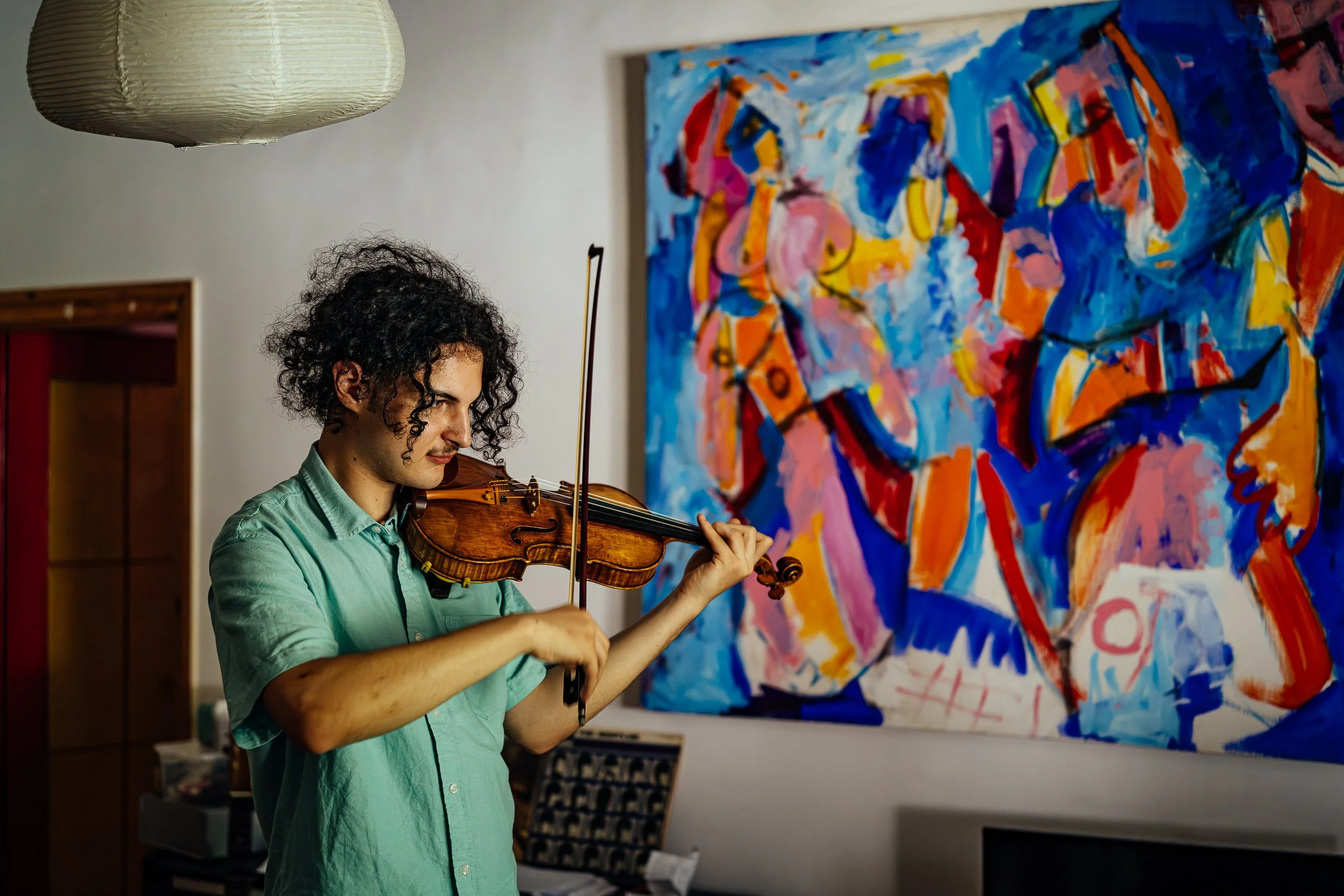 Simon practices the most in his family's living room. He is training to be a violinist. This is his first serious instrument, for which his entire family put together the money. His grandfather was a painter. 2025.
