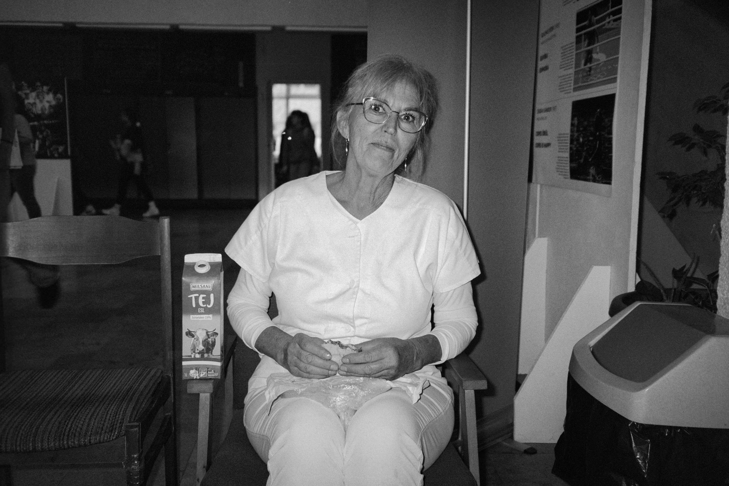 A technical school employee eats her lunch in the school hall. 2025.