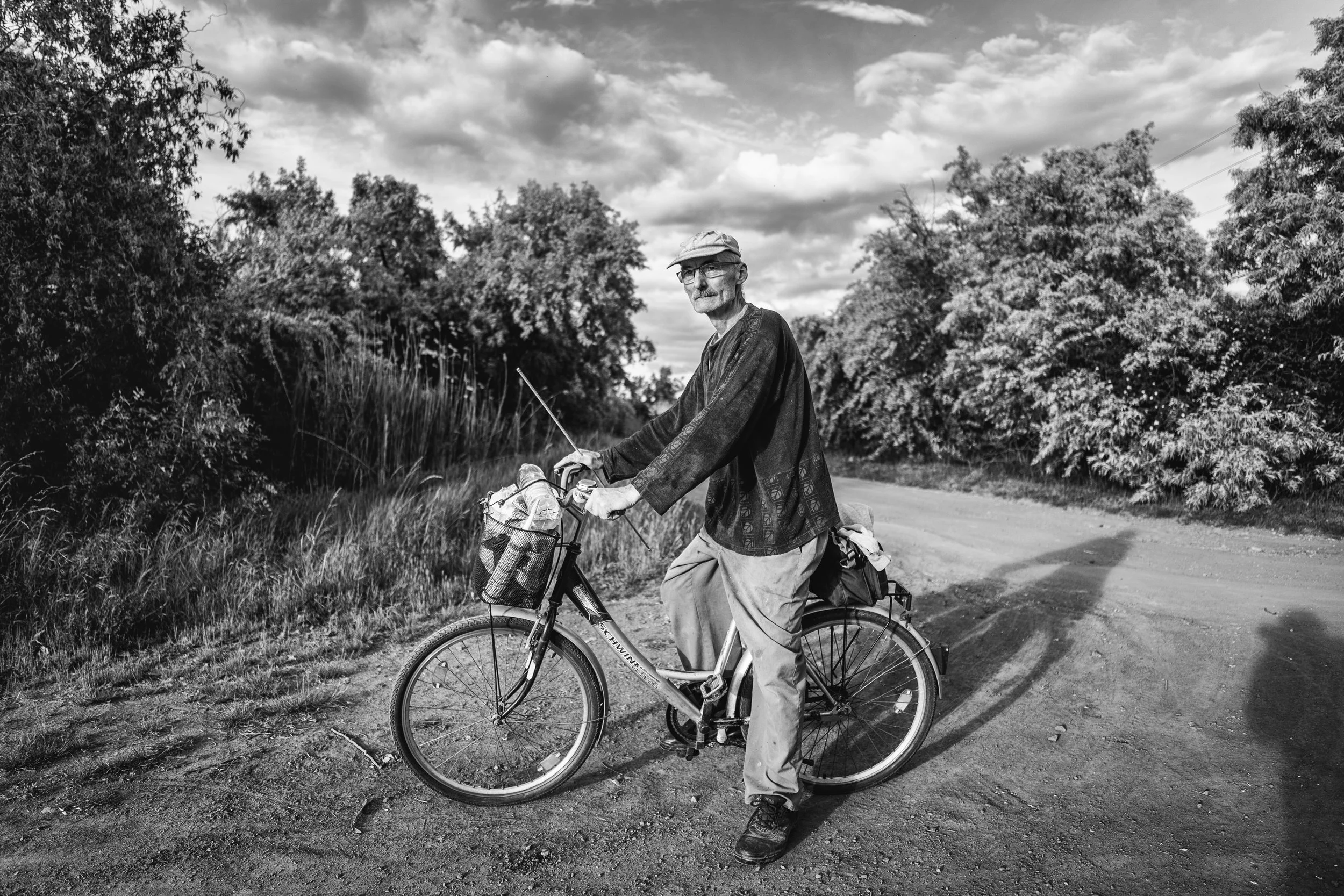 A man cycling on the road next to the lake stopped for a moment