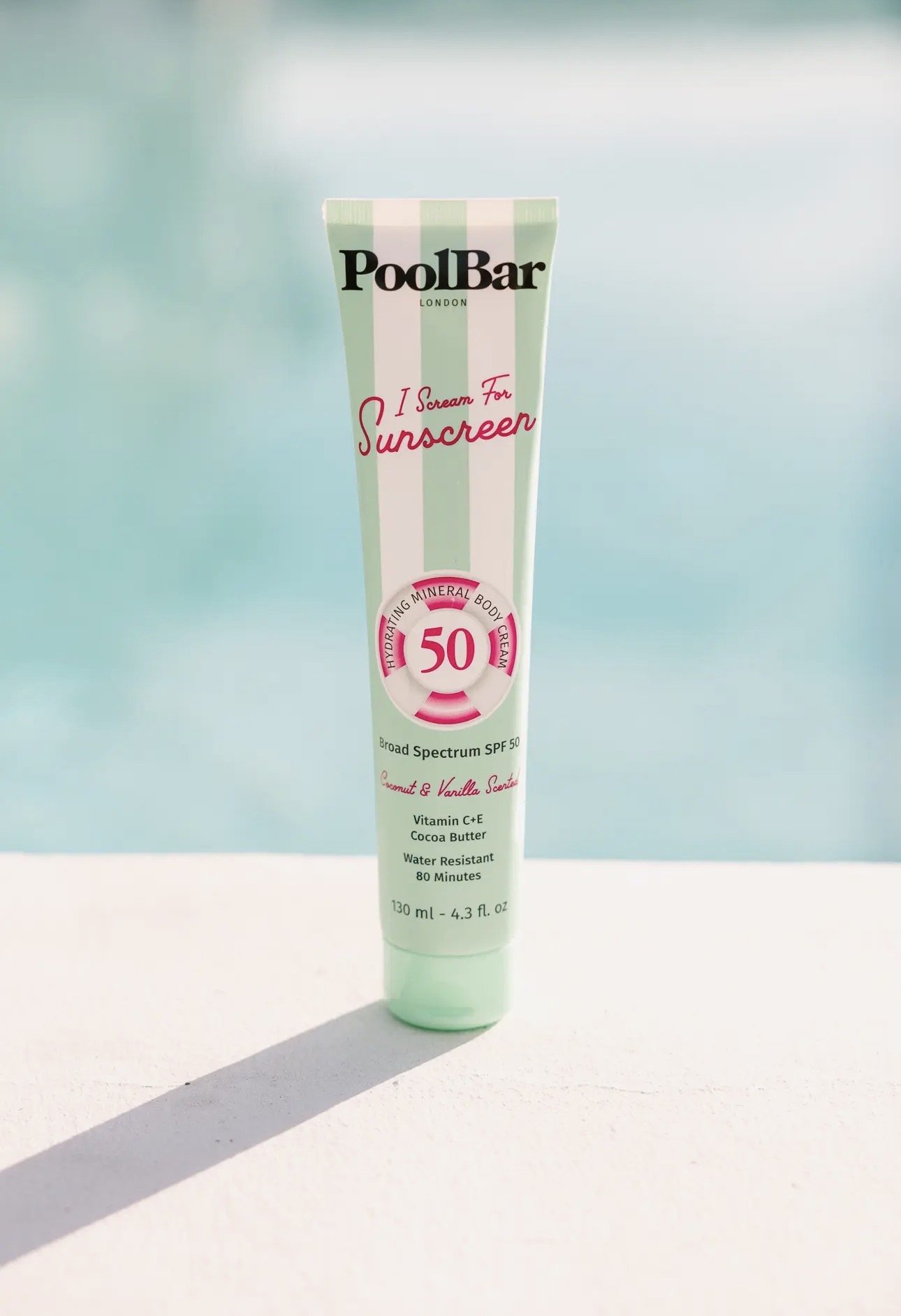 Tube of PoolBar London sunscreen with SPF 50 on a white surface with a light blue background.