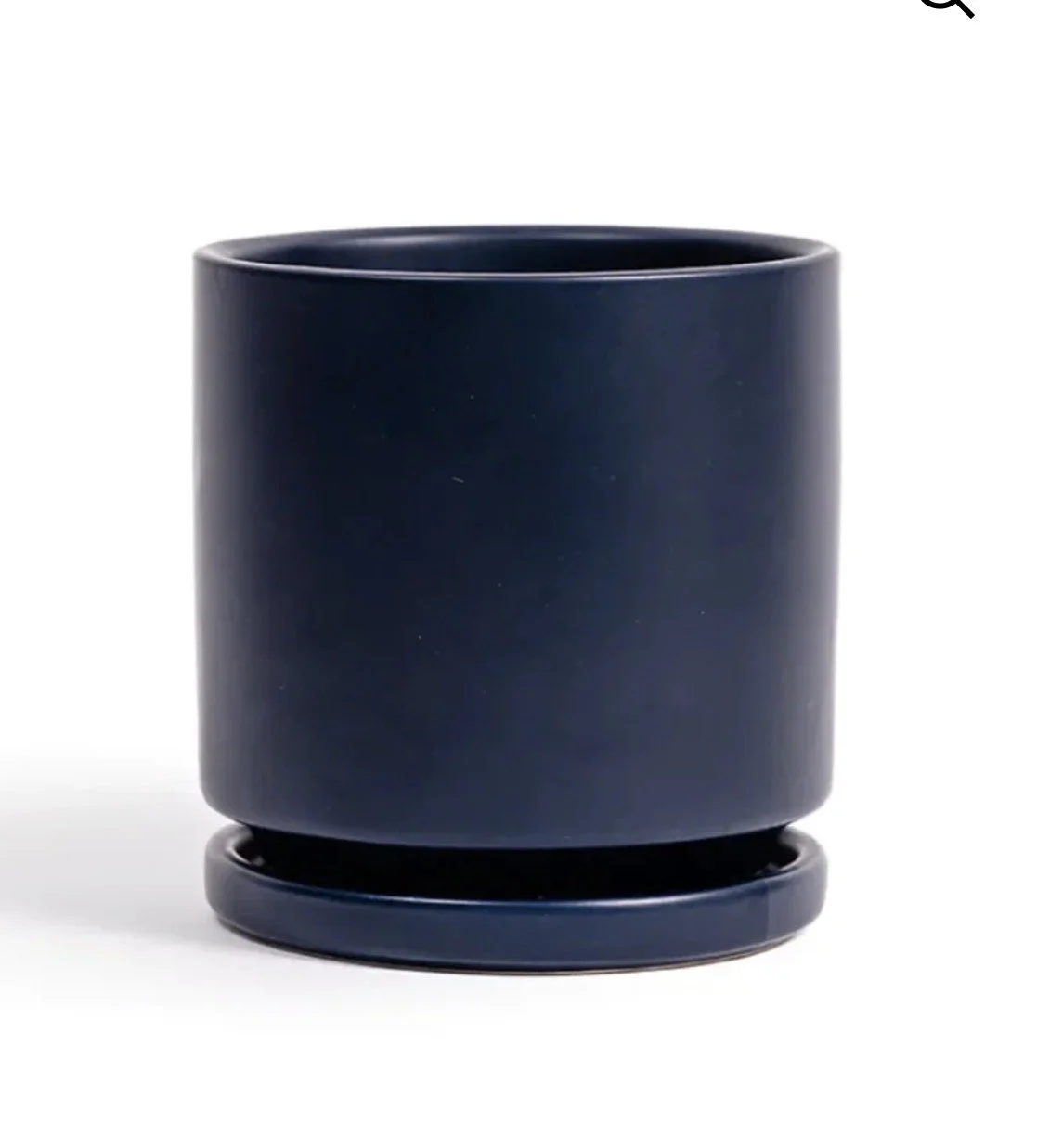 A black, cylindrical planter with a matching saucer underneath, set against a plain white background.