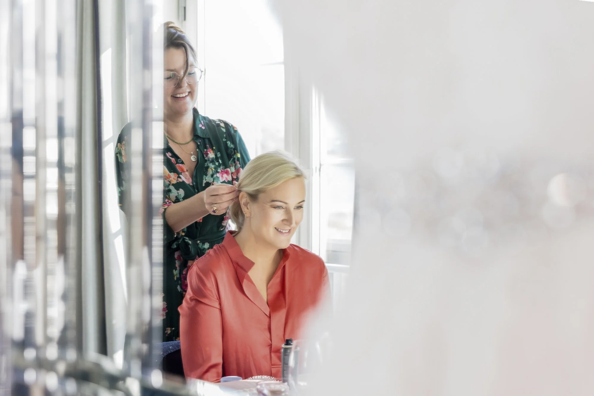 Kvinne får hårpleie av frisør i salong