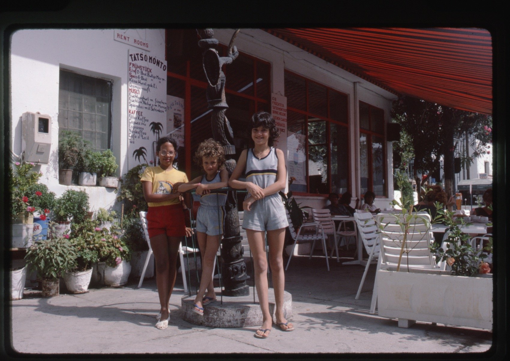 Mirsini with the sisters Zefi and Irini; Jack Whitten’s totem is visible in 
the harbour (1984). Photographer unknown.