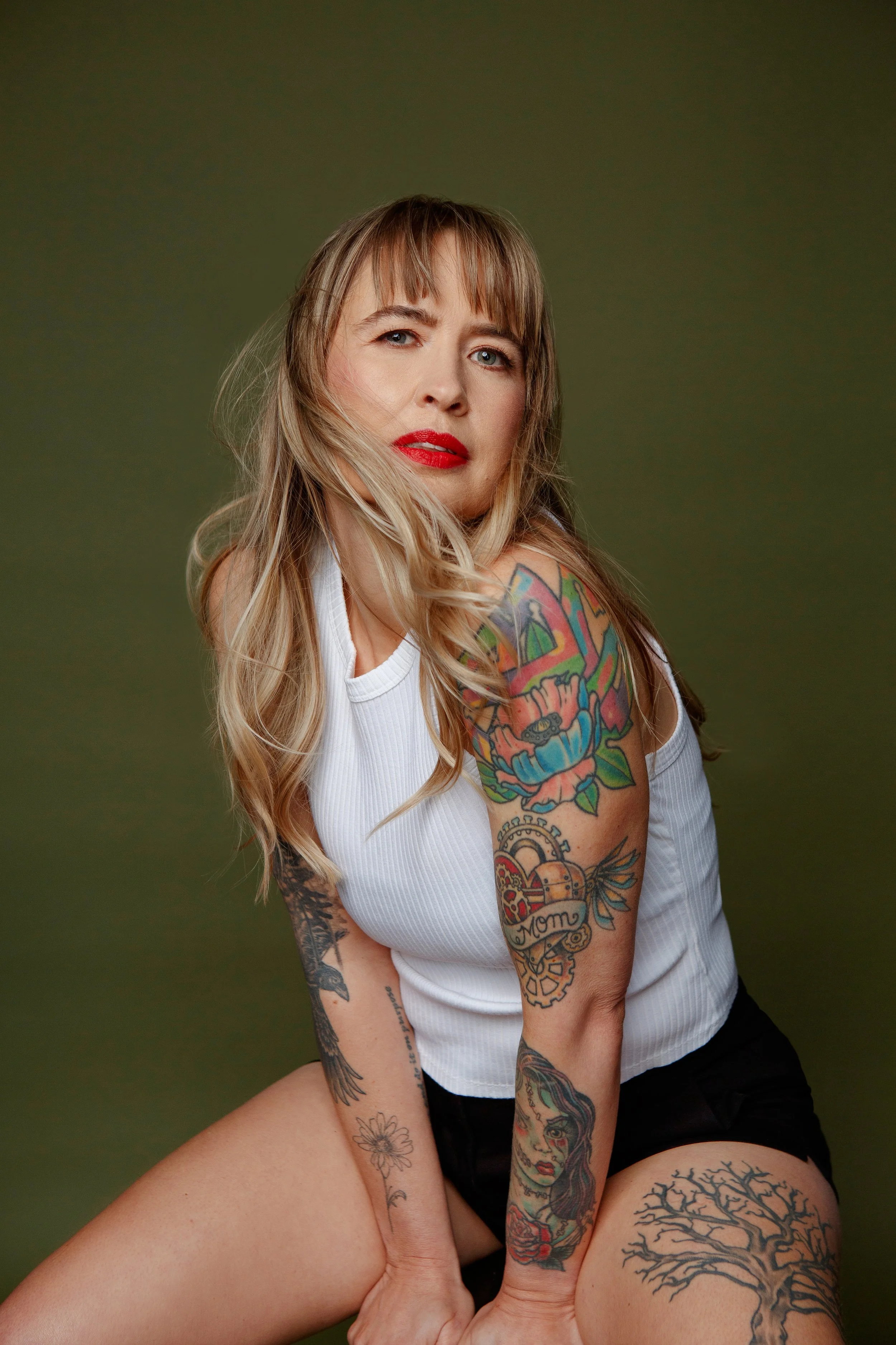 Studio portrait of a blonde woman with beautiful tattoos photographed for Worthy Woman portrait experience in Calgary.