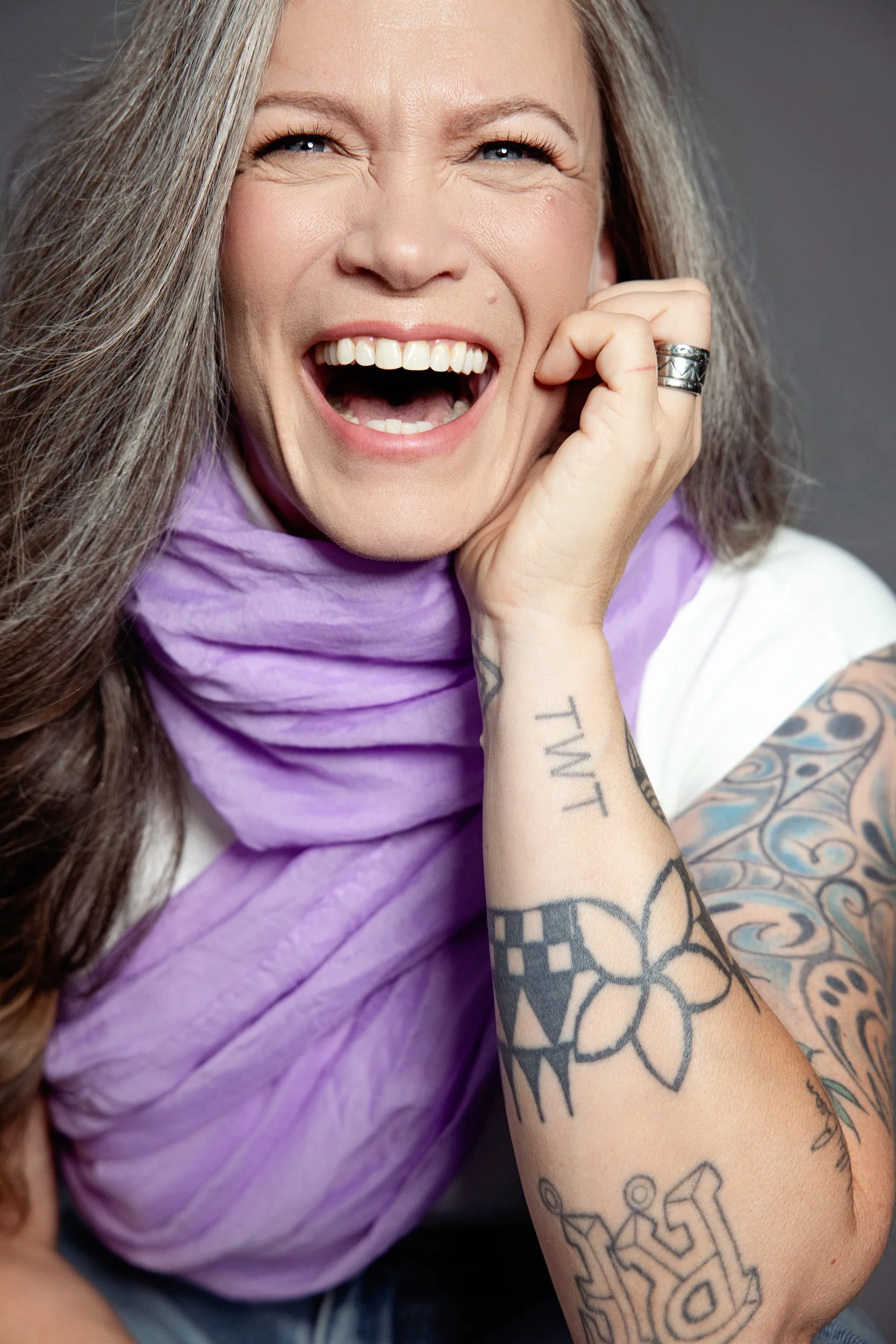 Close-up portrait of a woman in her 50s laughing, styled for a fitness and wellness modelling portfolio in Calgary.