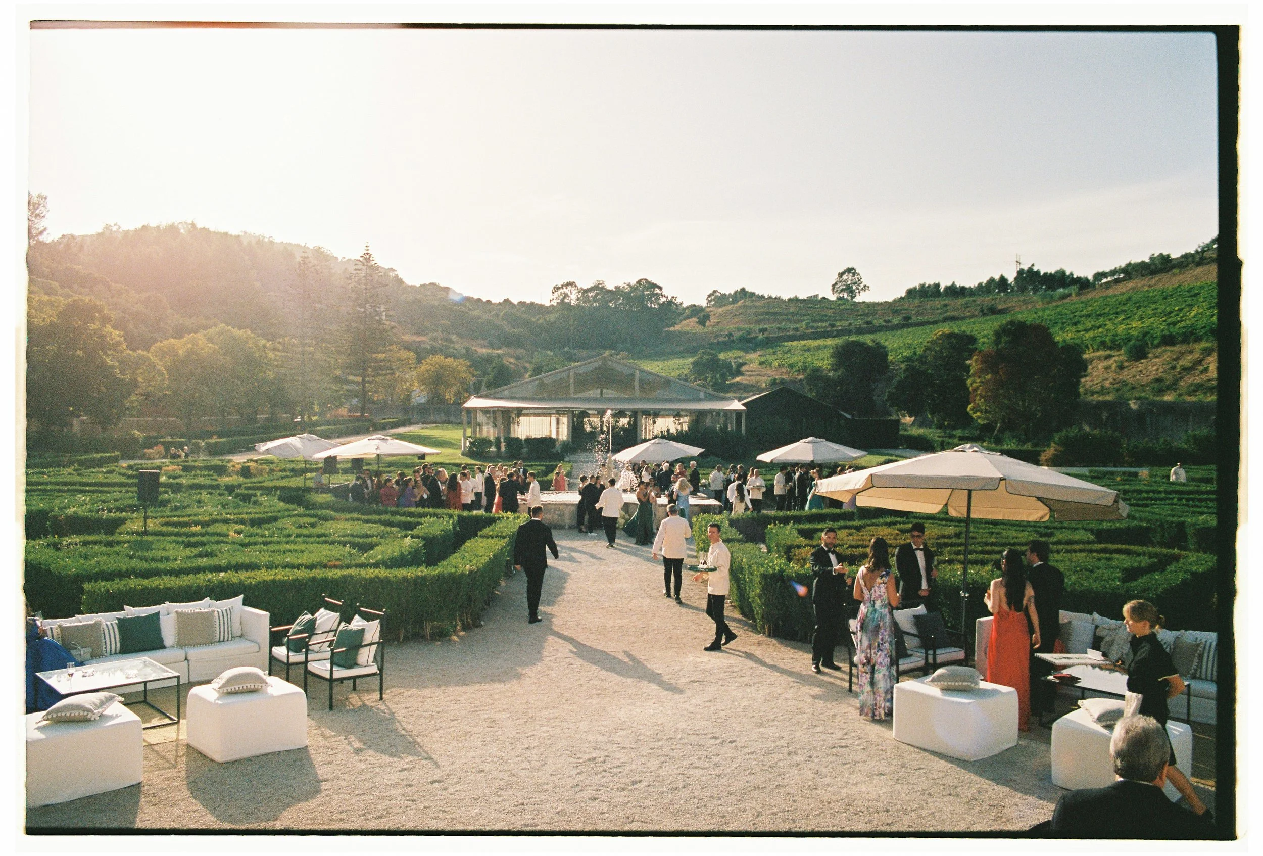 Guests enjoying cocktail hour in the gardens of Palácio do Correio-Mor during a destination wedding near Lisbon.