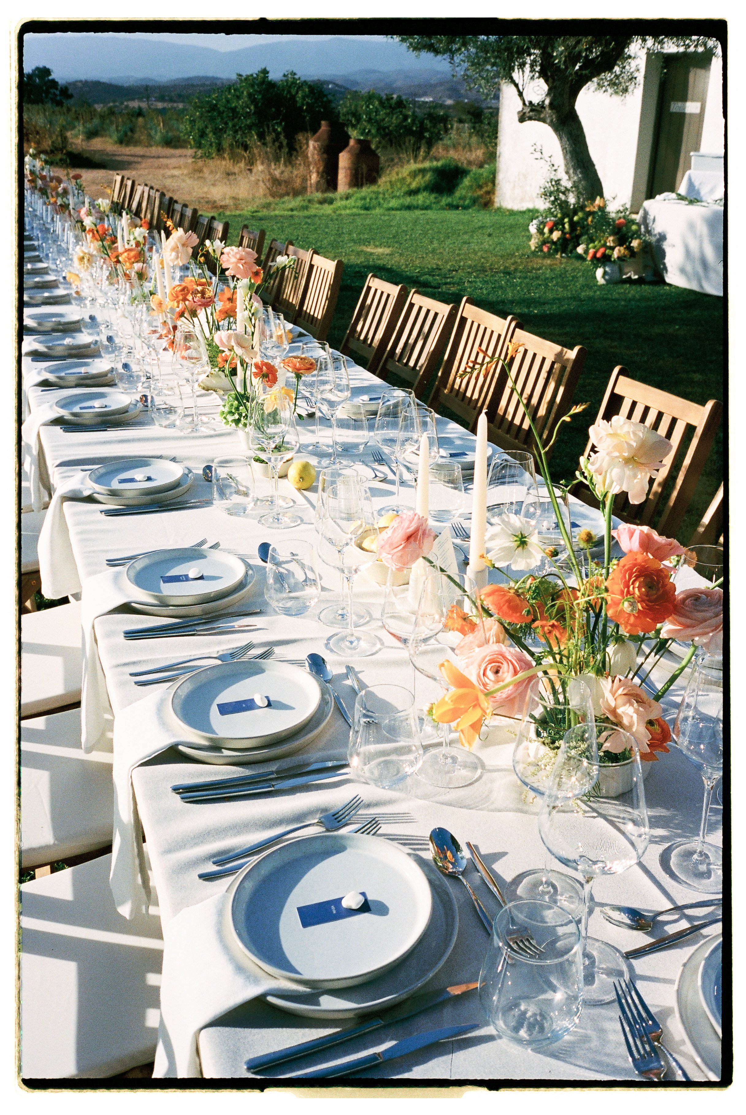 Elegant wedding table setup with flowers and candles during an outdoor vineyard dinner at Morgado do Quintão in the Algarve.