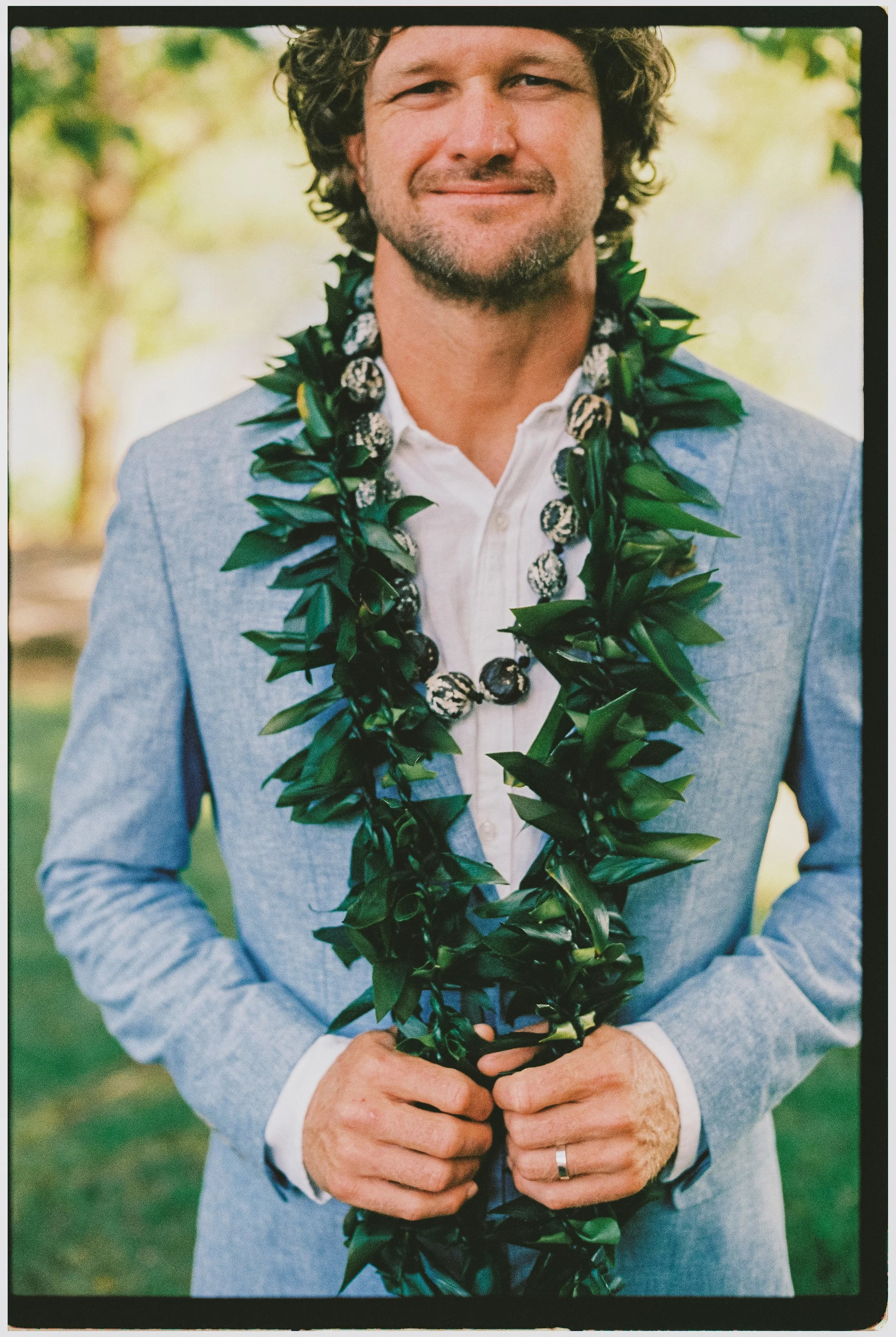 Groom wearing traditional Hawaiian lei during an intimate destination wedding in Portugal