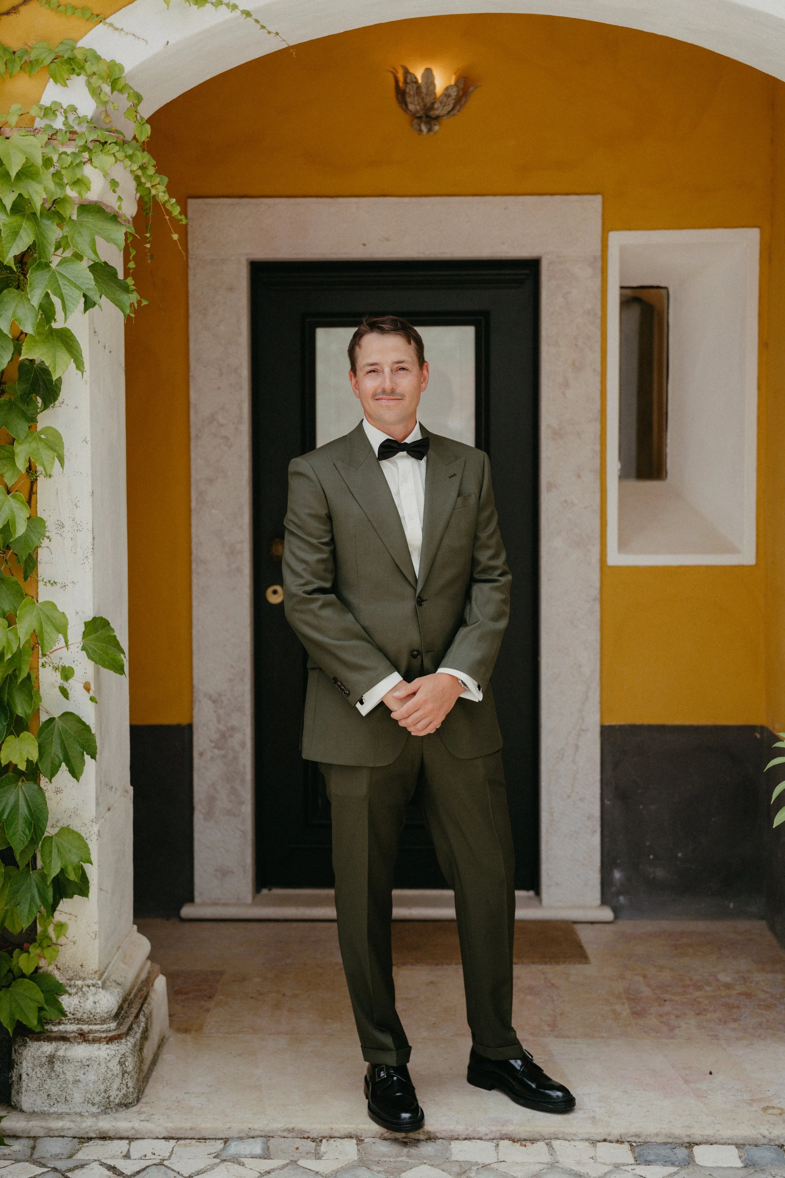 Groom portrait in tailored green suit at Quinta de Sant’Ana wedding venue in Mafra Portugal