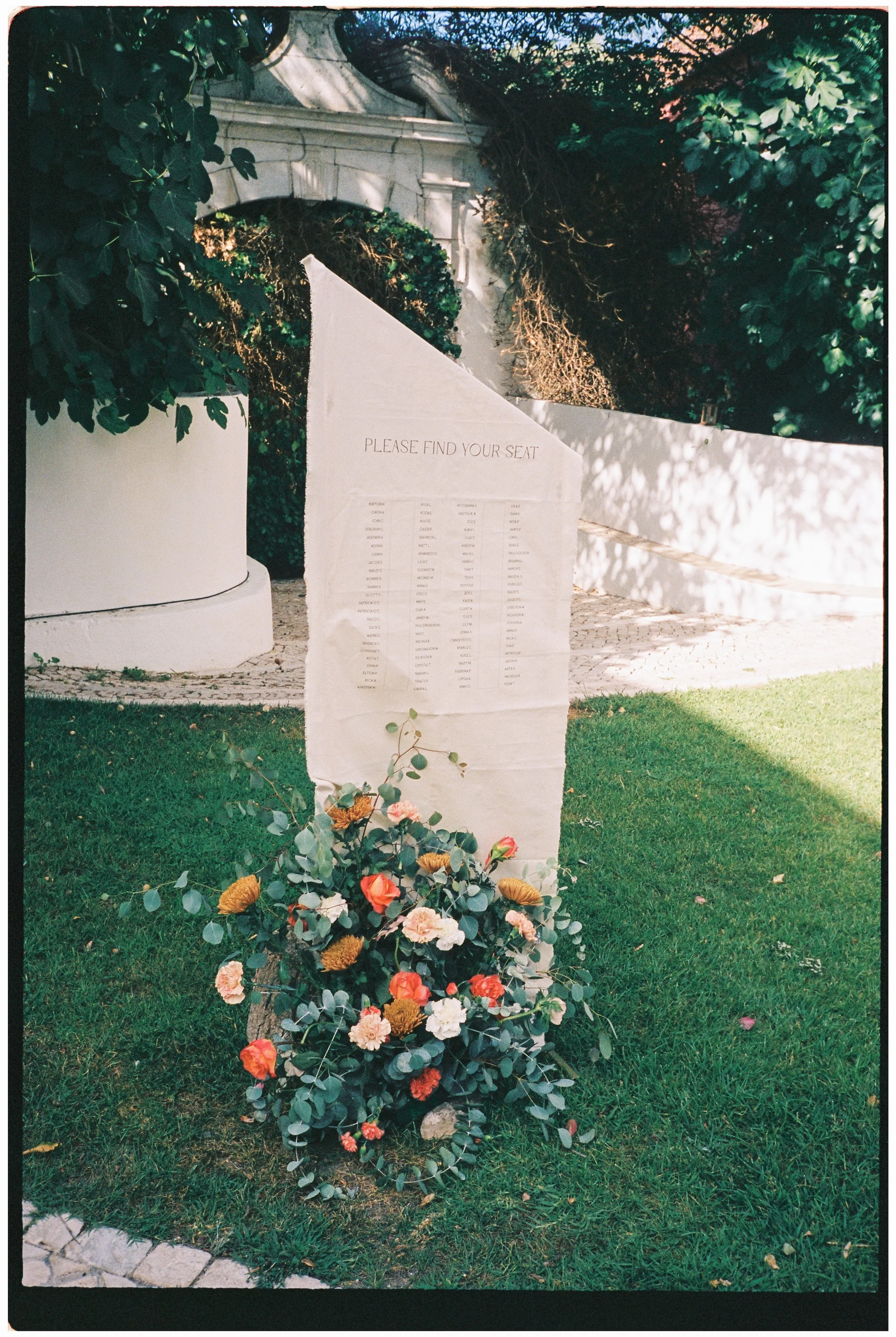 Outdoor wedding seating chart with floral arrangement during an intimate wedding in Portugal
