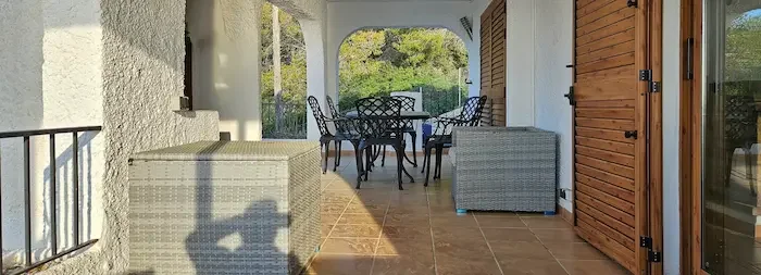 Overbygd spiseplass på terrassen ved Breizas hovedhus med utsikt over Costa del Azahar i Alcossebre
