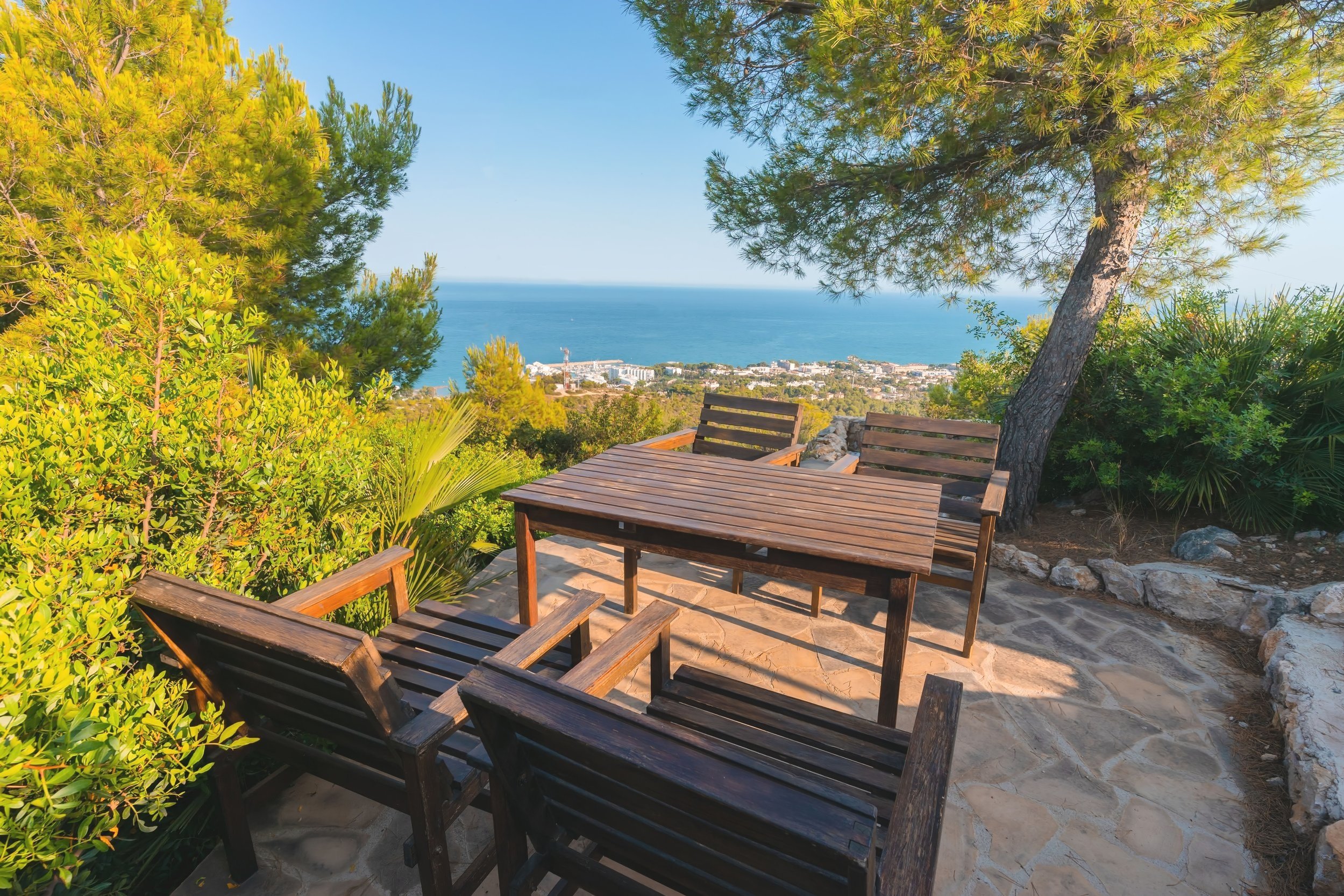 Breizas Nature Terrace: Scenic ocean view with table and chairs surrounded by greenery