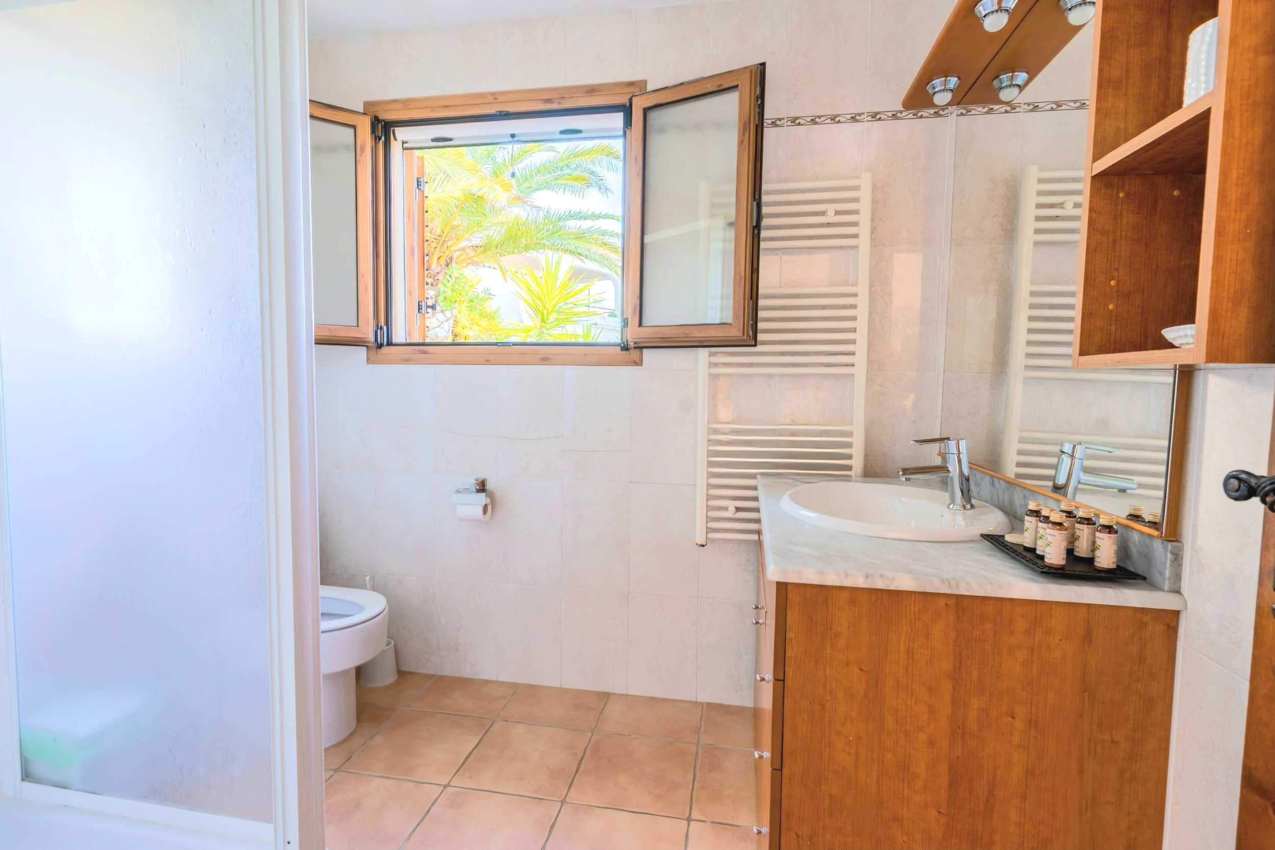 Moderno cuarto de baño en la planta baja de la Casa Principal con ducha a ras de suelo, lavabo e inodoro.