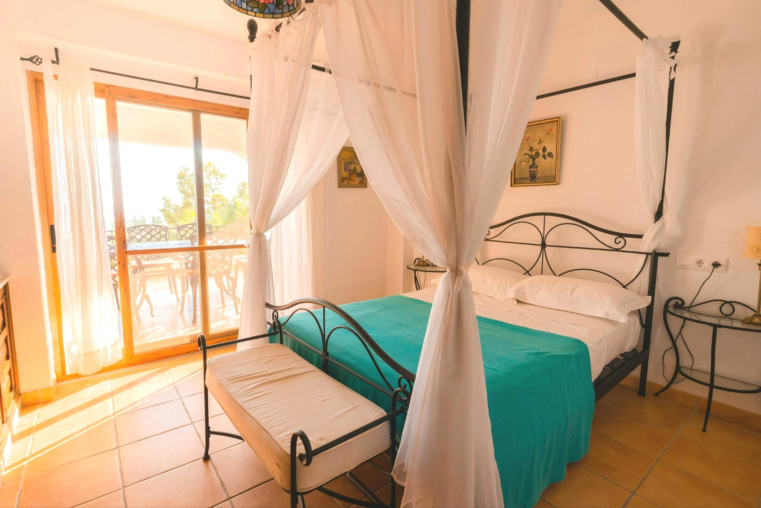 Spacious master bedroomwith four-poster bed and private balcony