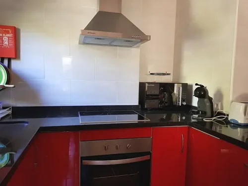 Moderne Küche mit schwarzer Arbeitsplatte und roten Schränken