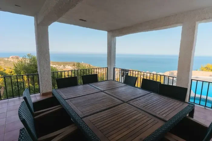 Overbygd terrasse med spisebord ute, privat basseng og havutsikt hos Breizas Villas i Alcossebre