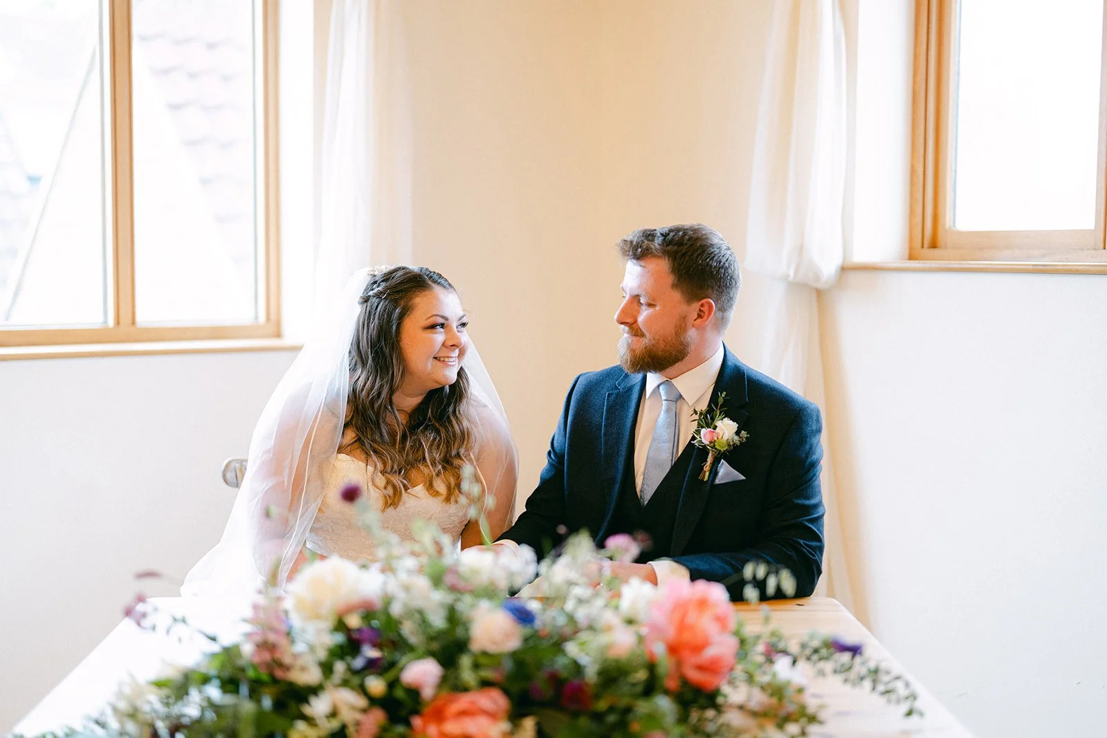 Bride and groom walking holding hands  through stone courtyard